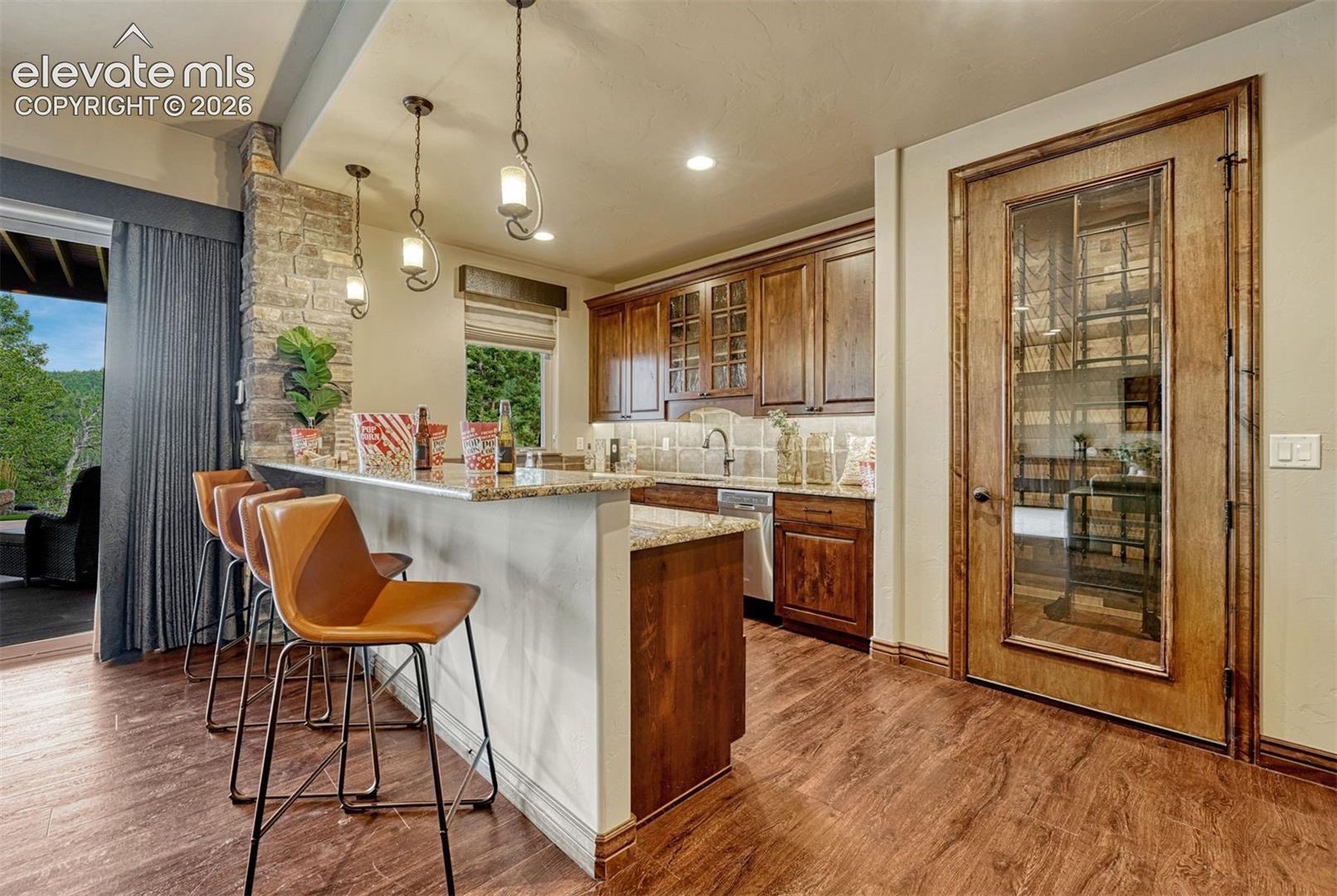 Wood-finish flooring throughout, complemented by a stone-clad column and a wood-paneled door with glass inserts