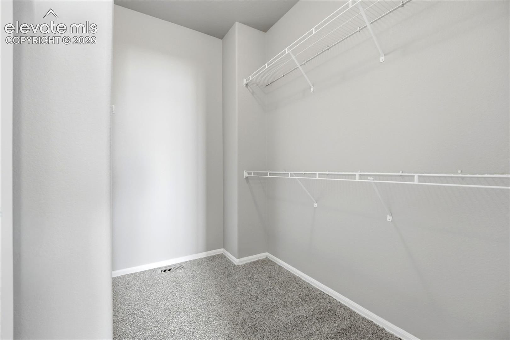 White wire shelving, light gray wall paint, and gray carpeting