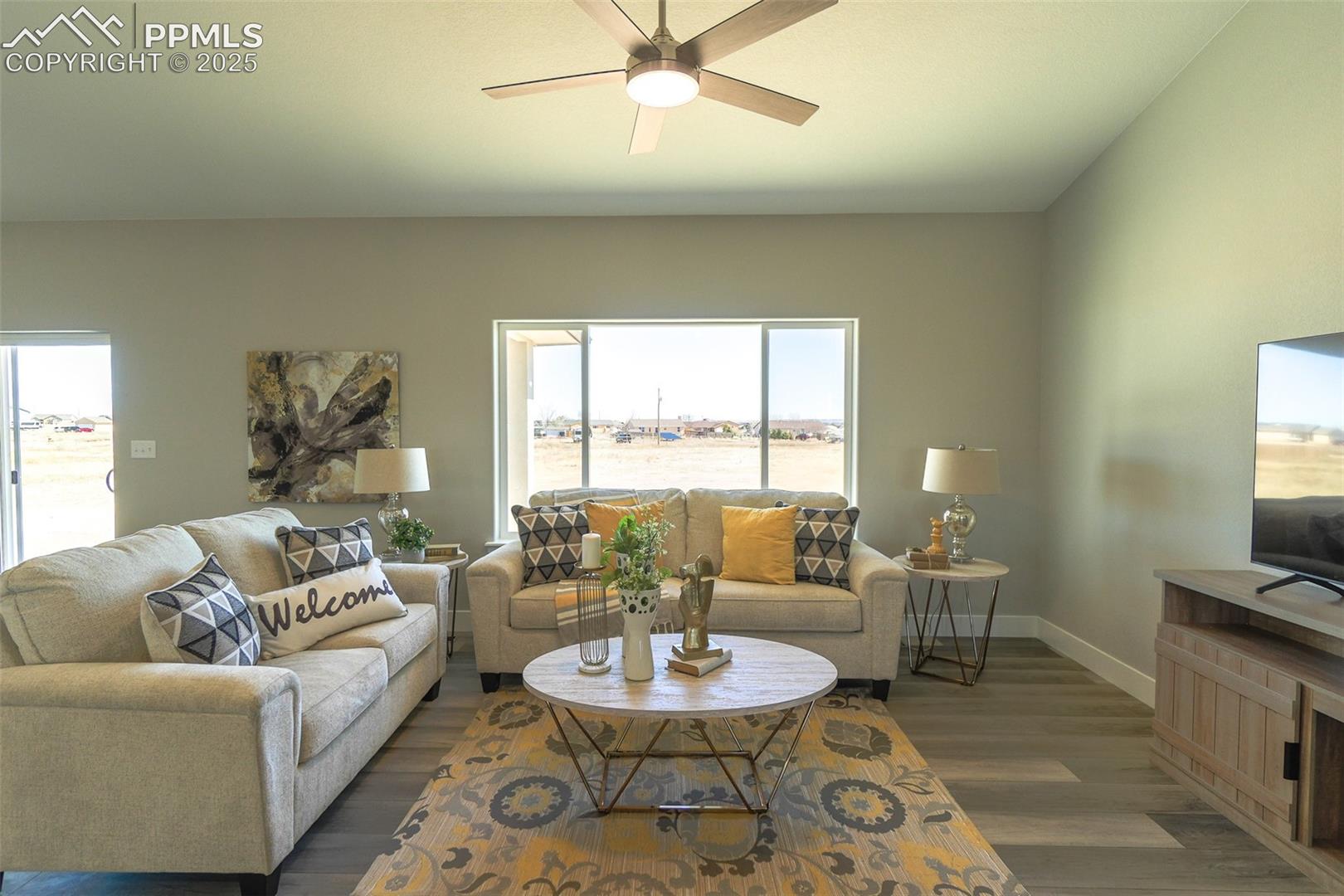 Living room with ceiling fan and LTV/ wood-style floors