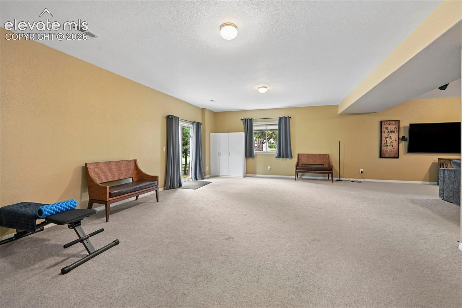 Spacious room with light-colored carpeting, recessed lighting, and a neutral wall color