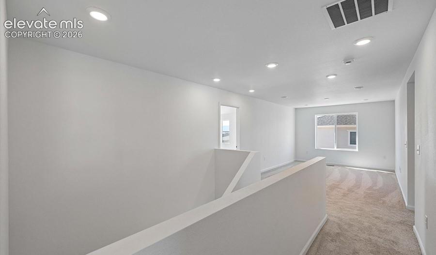 Interior area featuring neutral wall paint, recessed lighting, carpeted flooring, and a window with natural light