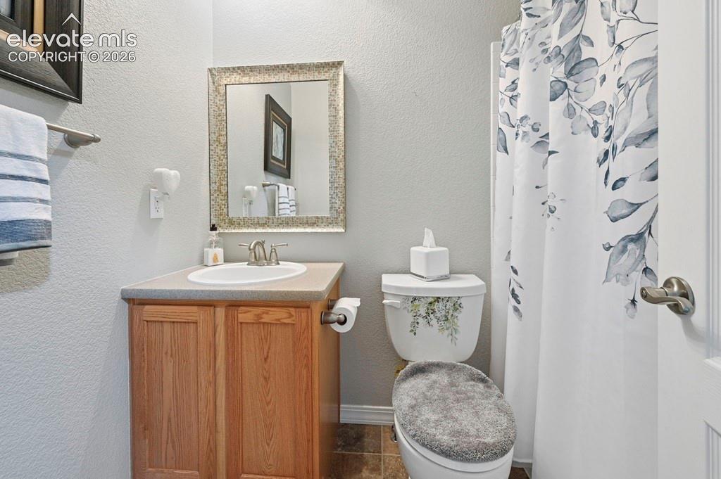 Single vanity with wood-finish cabinetry, integrated sink, and brushed nickel faucet