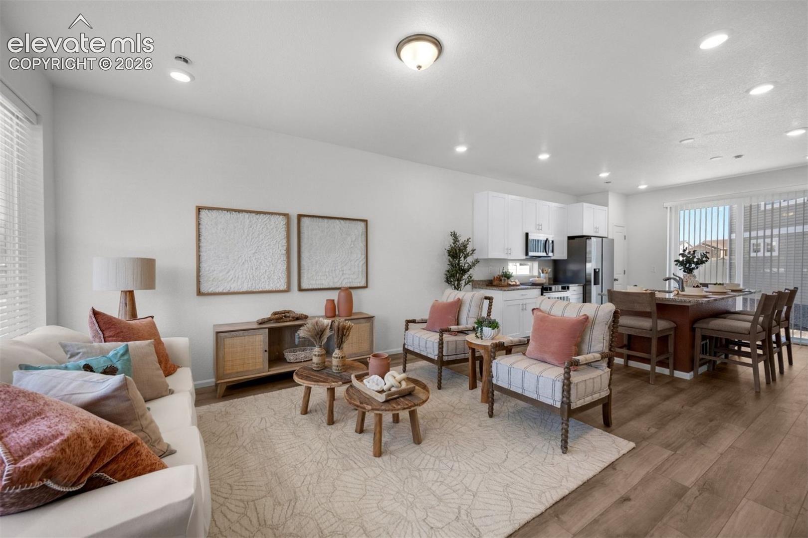 Open-concept living space featuring wood-finish flooring, recessed lighting, and white walls
*photos of a model home*