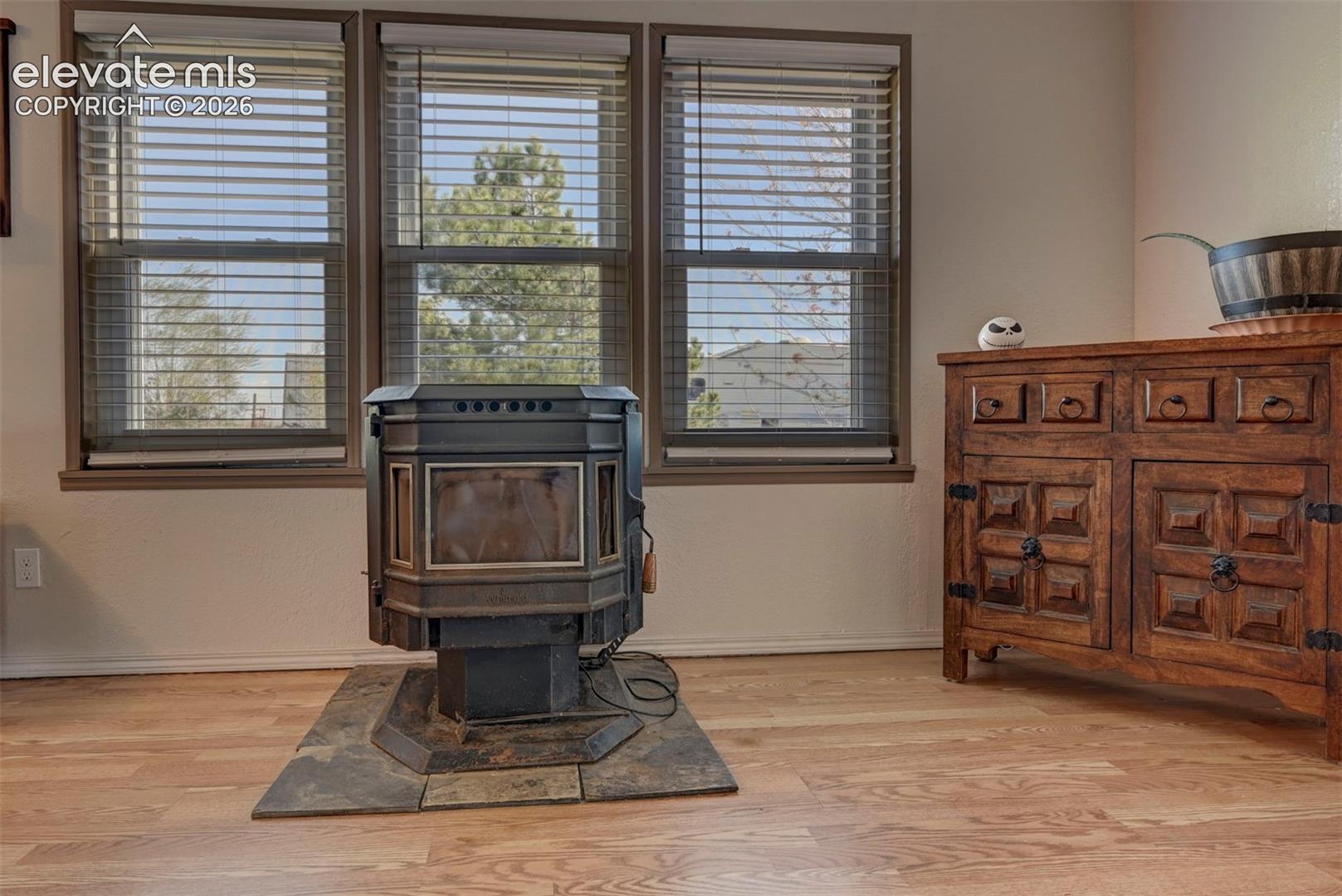 Detailed view of a wood stove, wood finished floors, and a textured wall