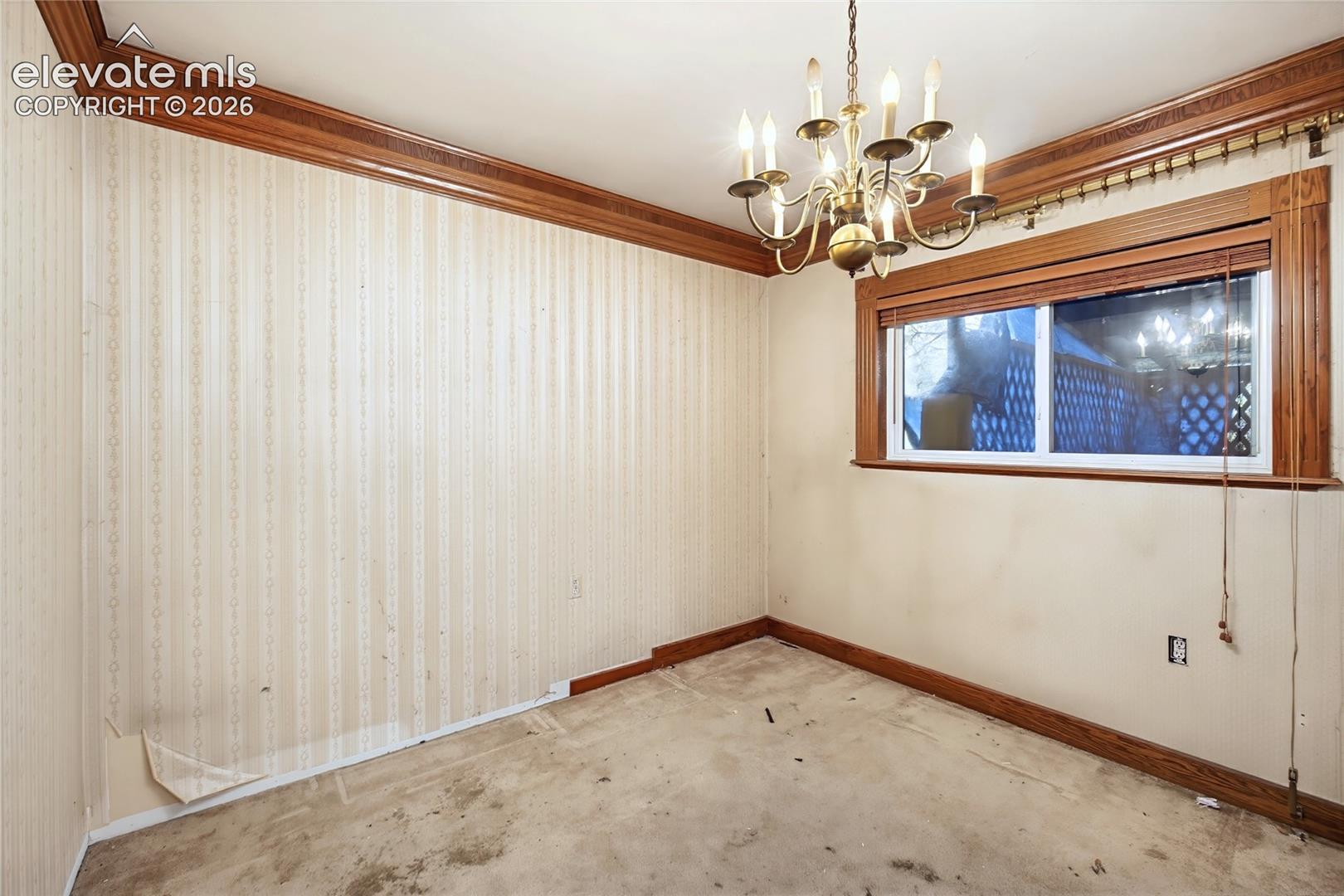 Brass chandelier, wood window trim, wood crown molding, wood baseboards, single window