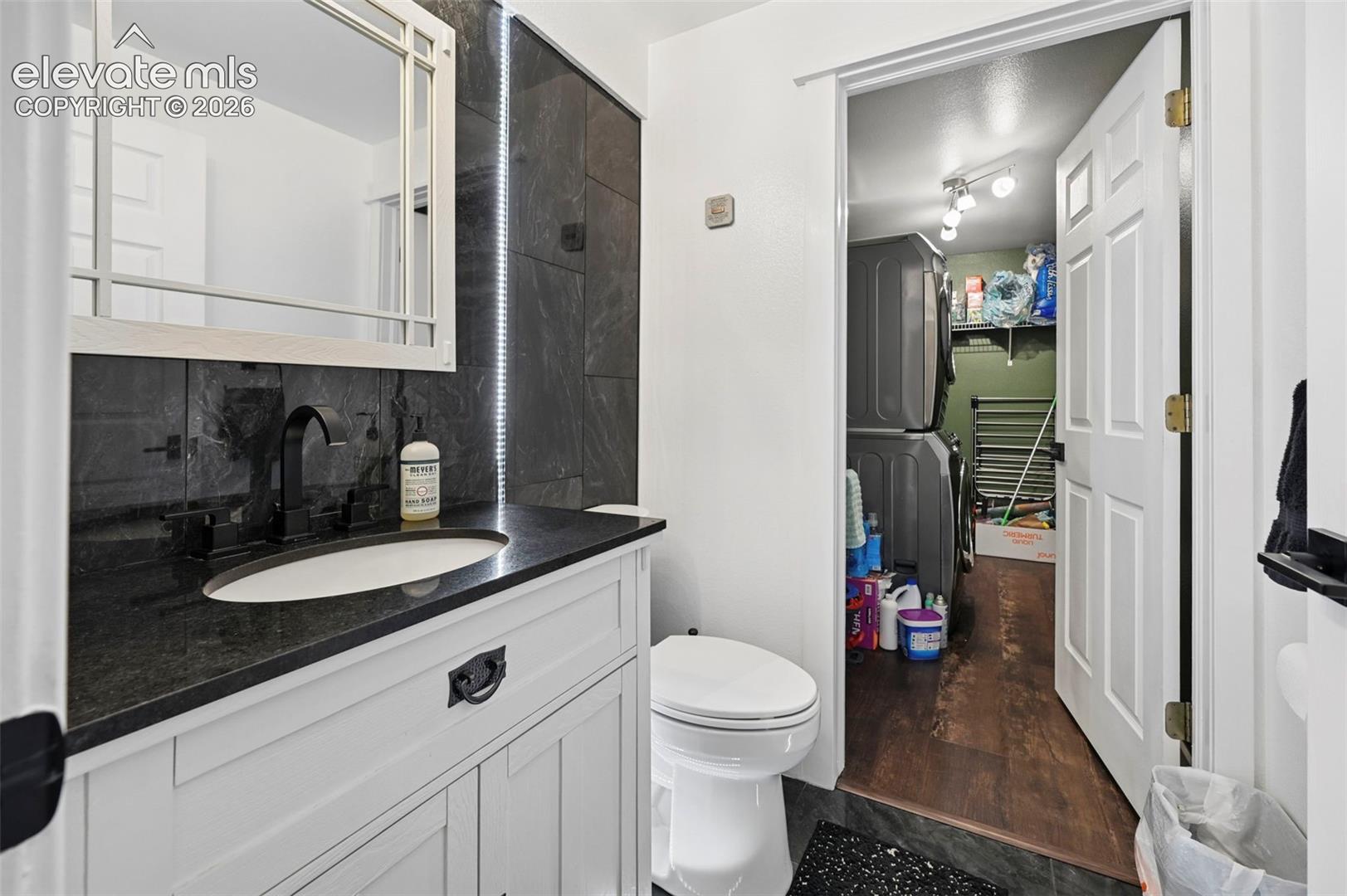 White shaker-style vanity with a dark countertop and integrated sink
