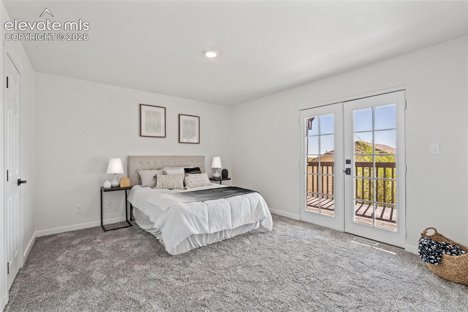 Neutral interior featuring plush wall-to-wall carpeting, recessed lighting, and double-pane French doors with integrated grid detailing providing access to a deck