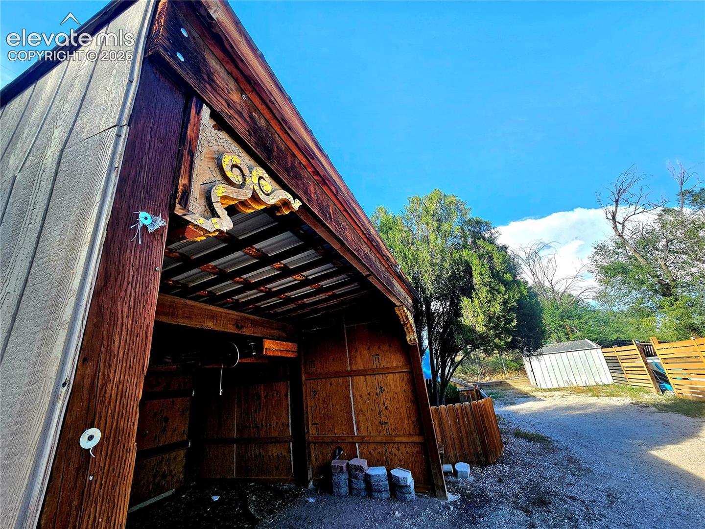 Partially enclosed carport with corbels