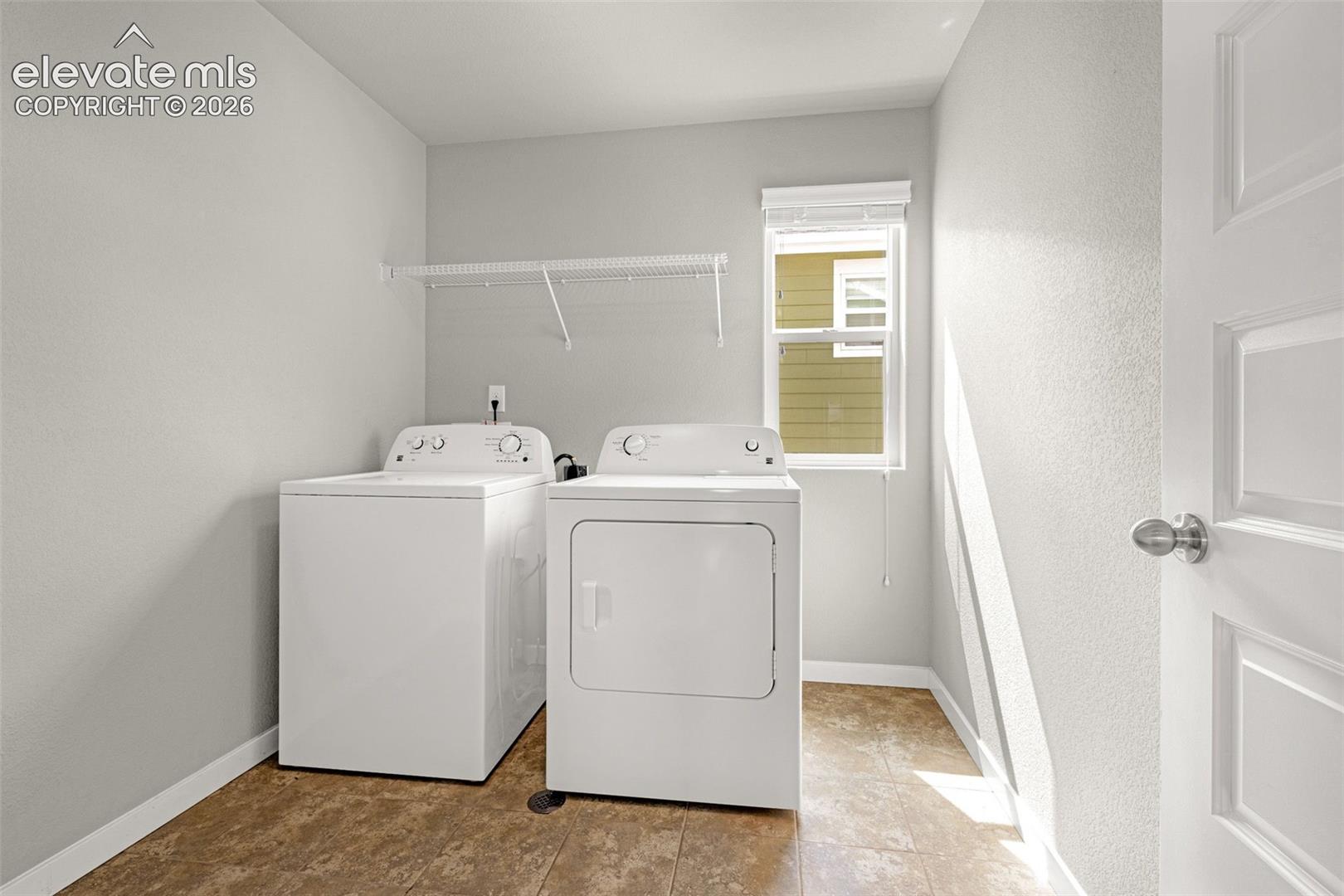 Utility room with durable flooring, a single window, and a built-in wire shelf