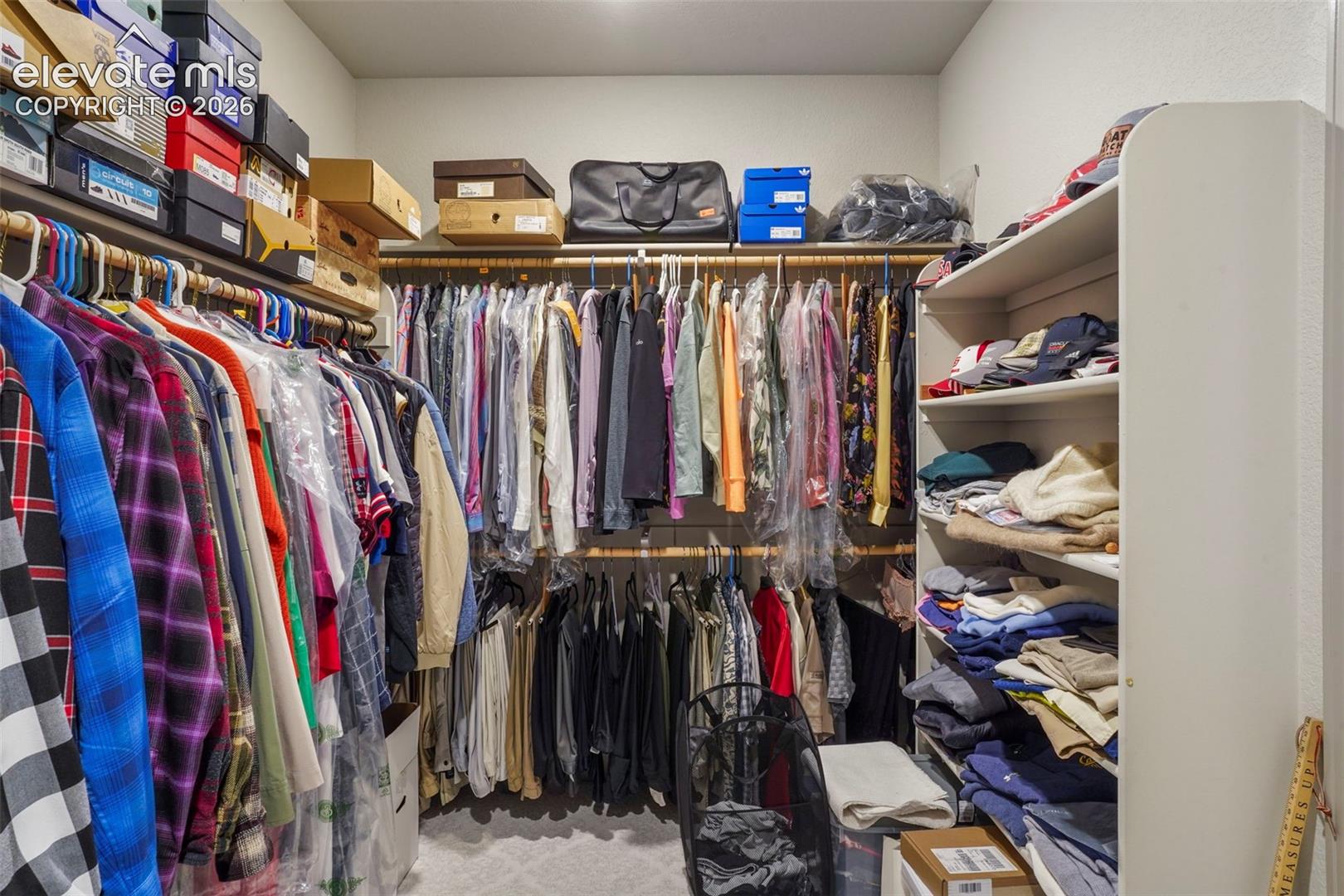 Walk-in closet featuring extensive built-in shelving, multiple hanging rods, and recessed lighting