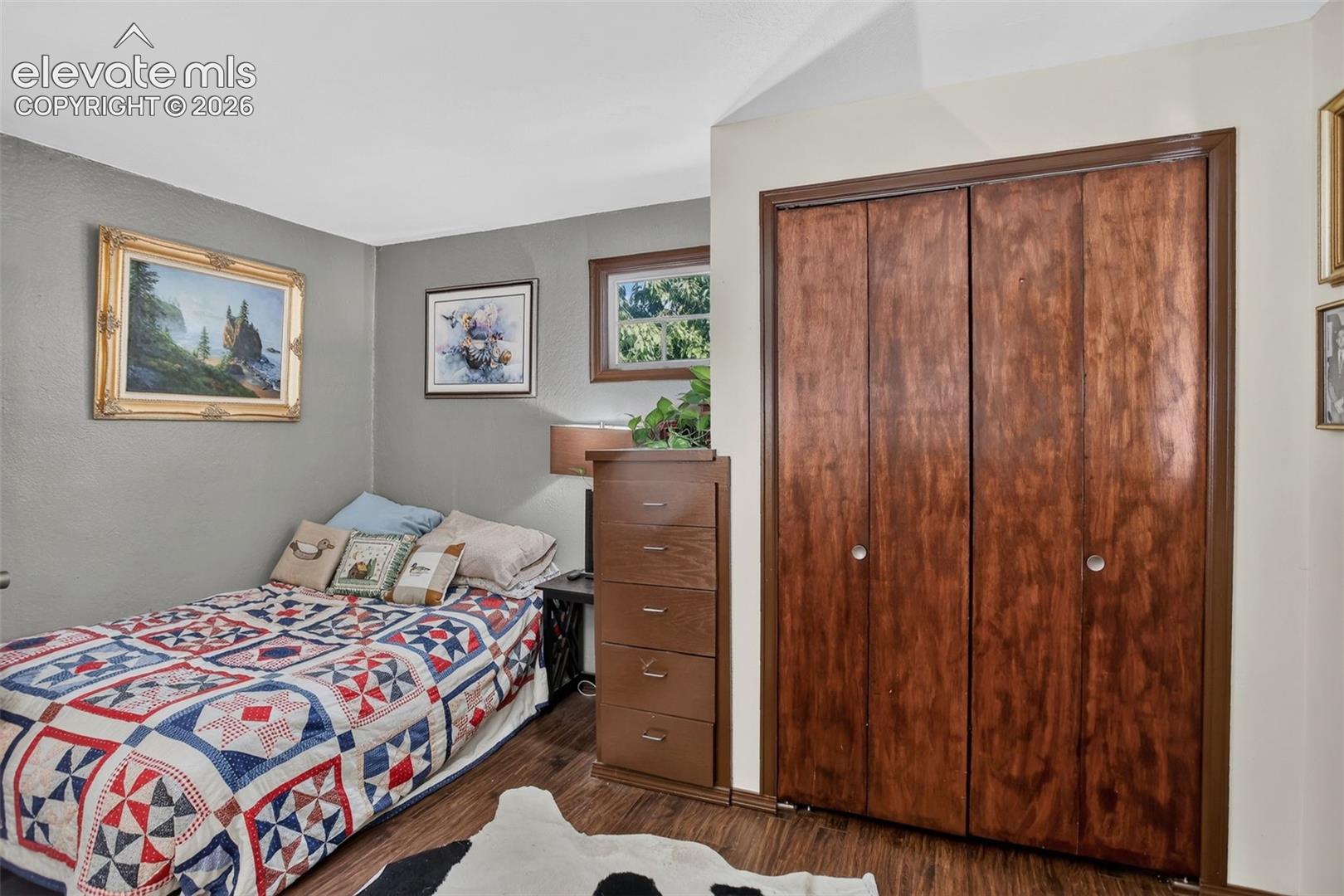 Wood-finish flooring with a bi-fold closet, and a framed window