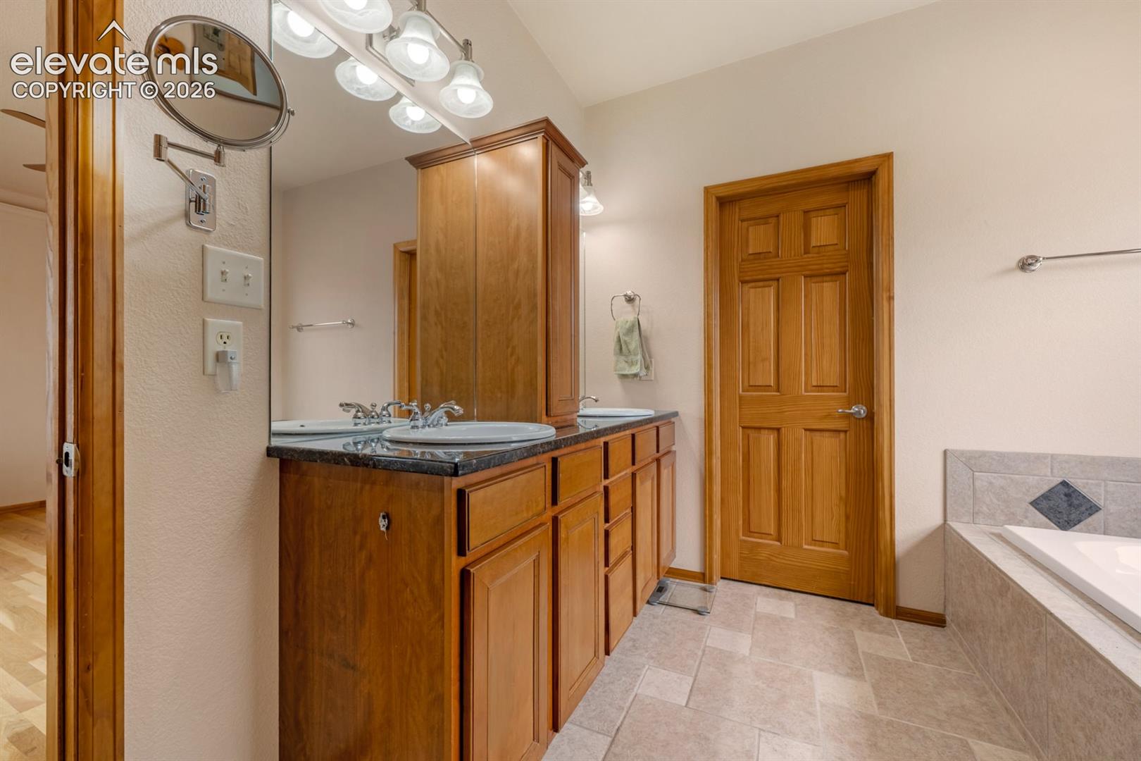 A true 5 piece bathroom.  Spa like bath offers a luxurious soaking tub, stunning walk in shower with a see through mirror. Granite counters.  Step into an extra large walk in closet rivaling boutique dresssing rooms.
