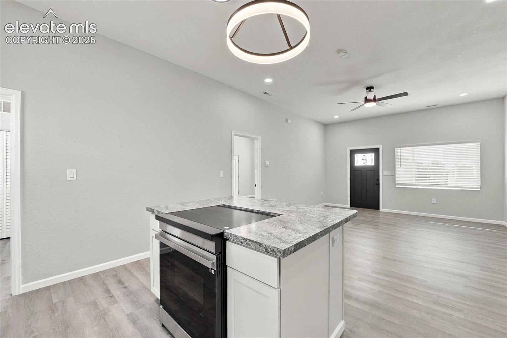 Kitchen island with integrated stainless-steel range and stone-look countertop