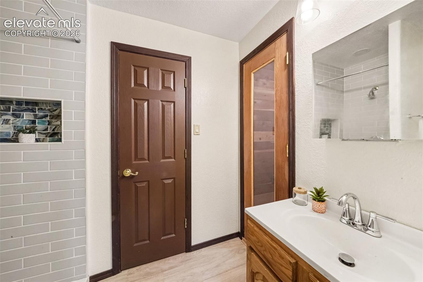 Jack-and-Jill bathroom conveniently connects the basement bedroom and features a partially completed cedar dry sauna