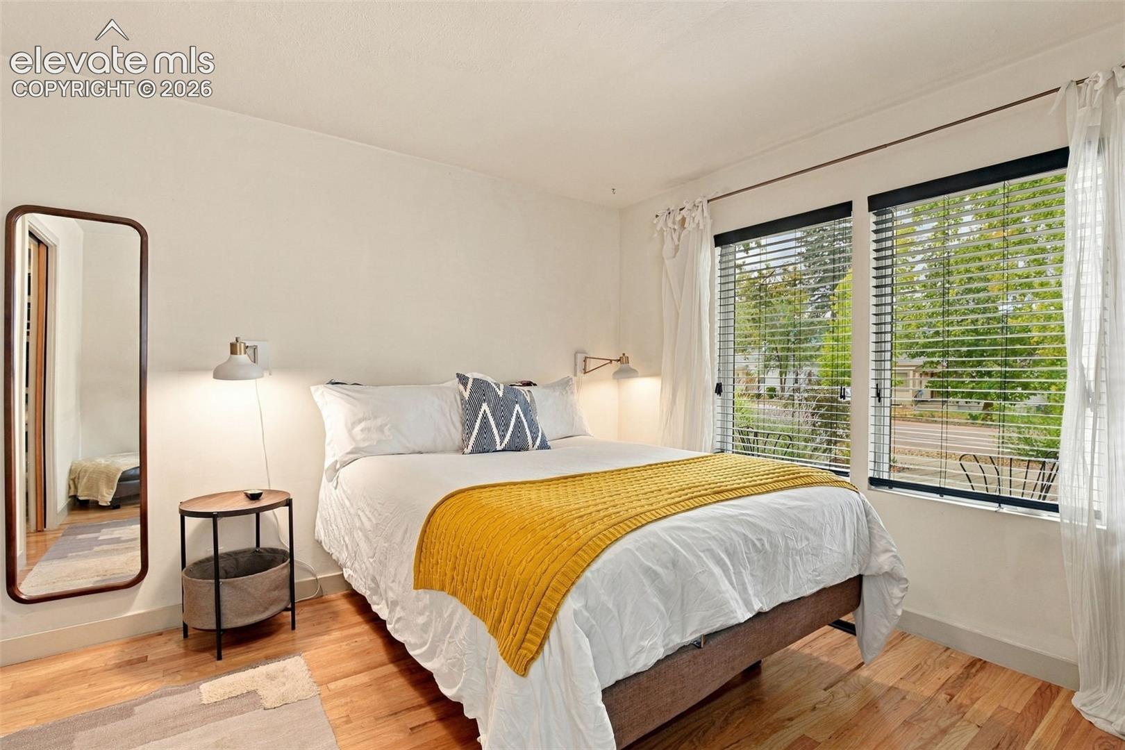 Hardwood flooring and dual-pane windows with horizontal blinds