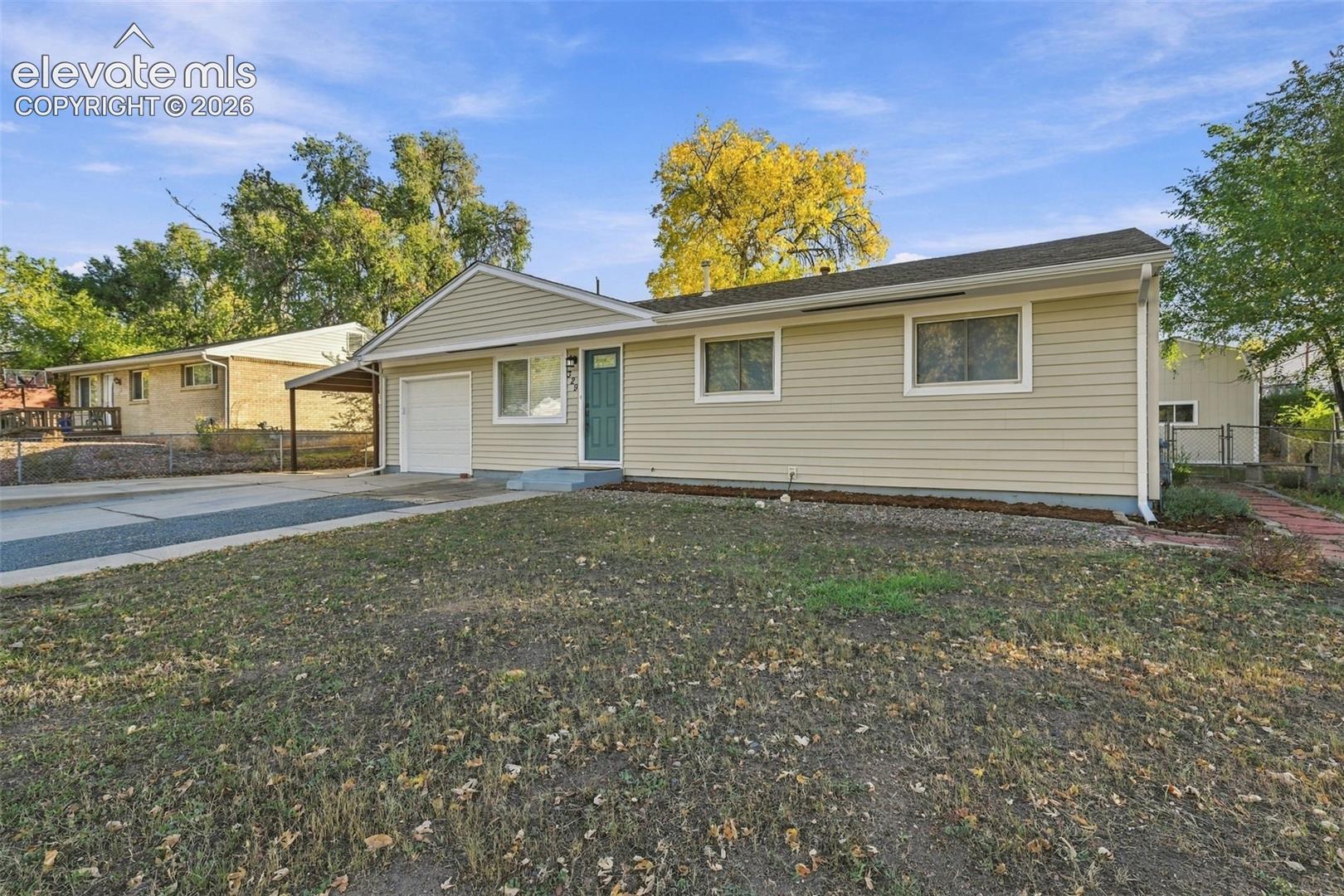 Single-story exterior featuring light-toned horizontal siding, a covered carport, an attached one-car garage, and a concrete driveway