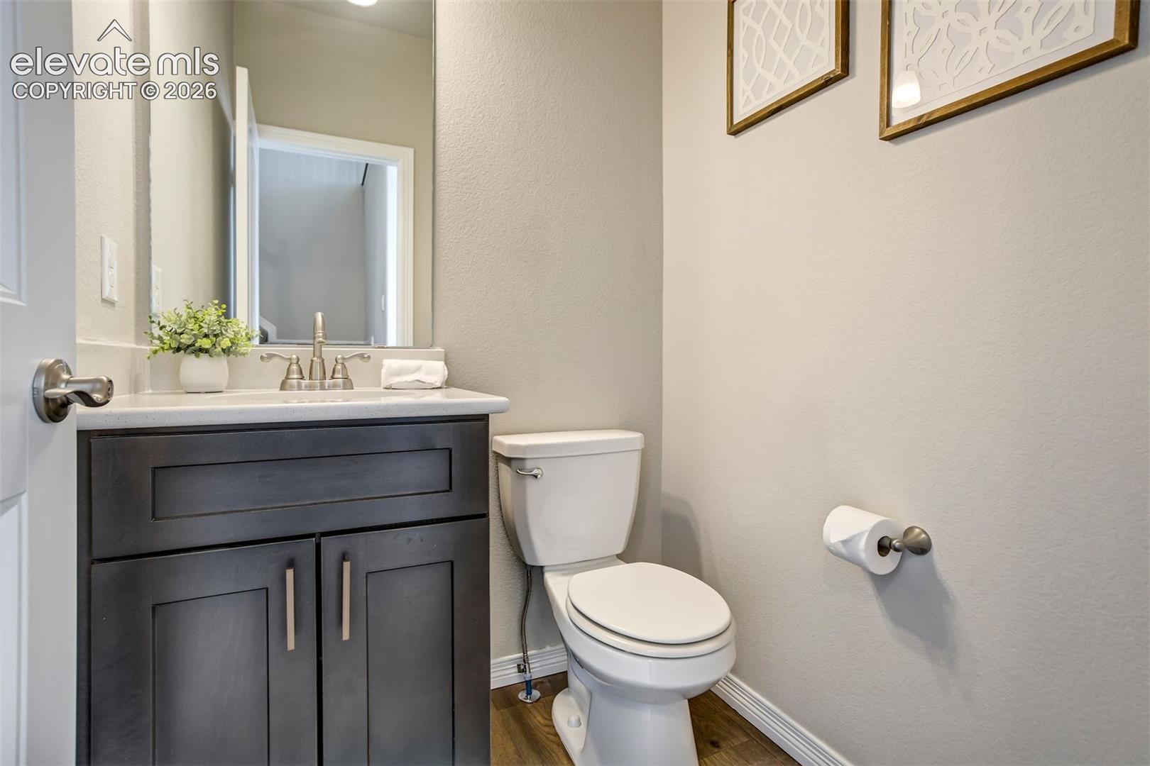 Dark wood-finish vanity with a light-colored countertop and brushed nickel hardware