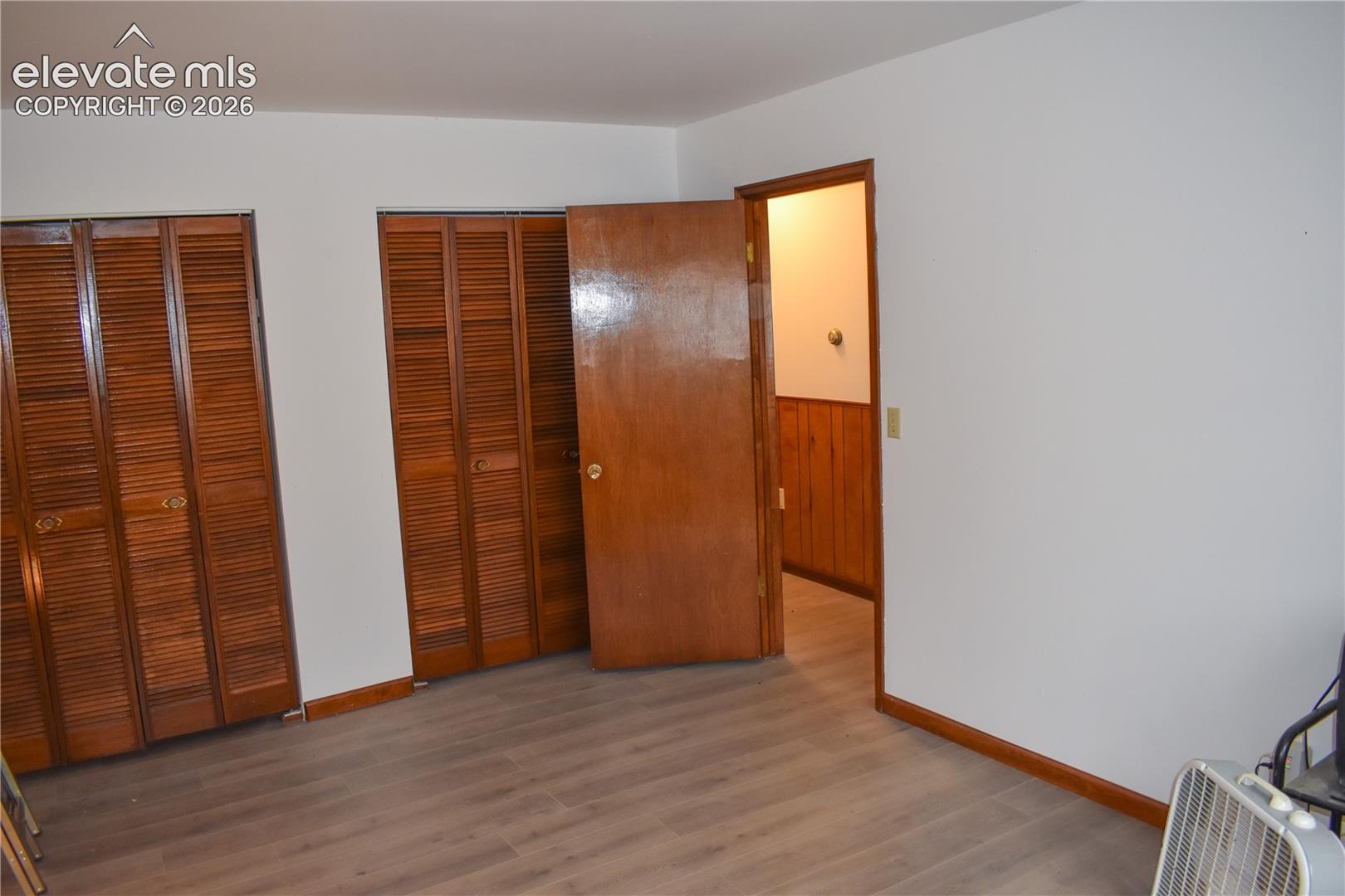 Wood-finish flooring with white walls and wood trim