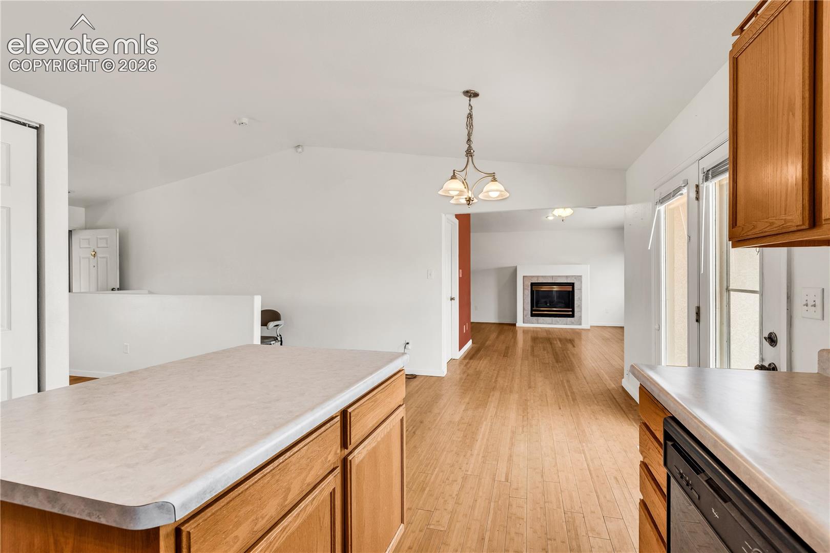 Wood-finish flooring throughout, vaulted ceiling, and recessed lighting