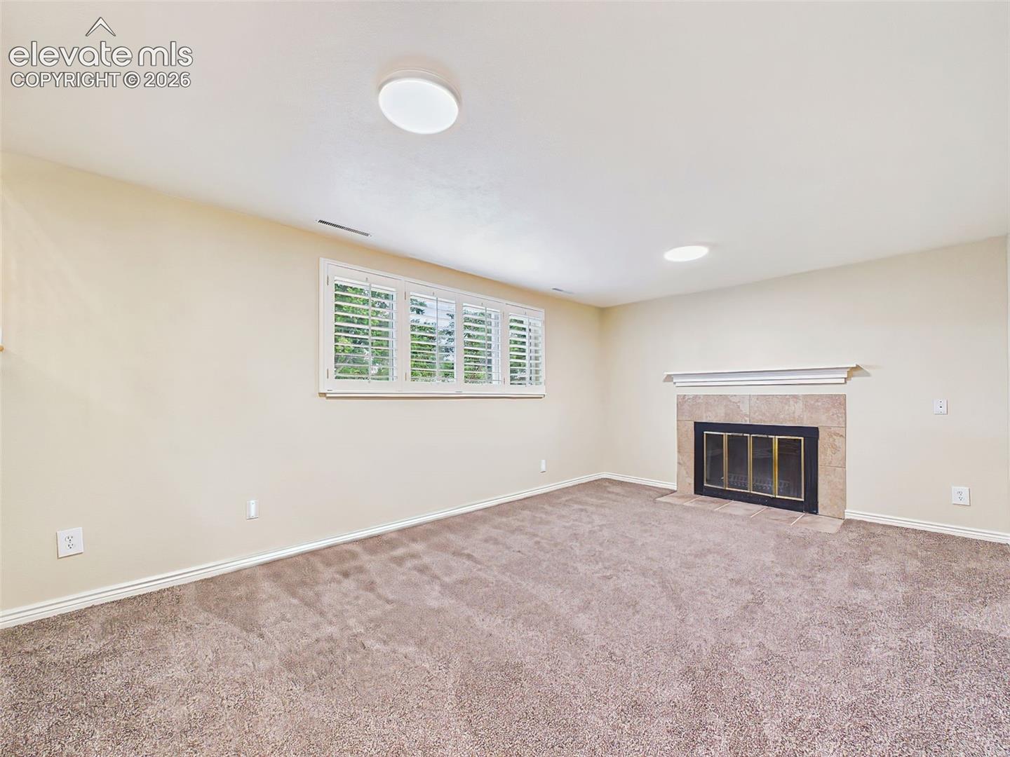 Family Room – Another view highlights the large window with plantation shutters, abundant natural light, and comfortable open floor plan.