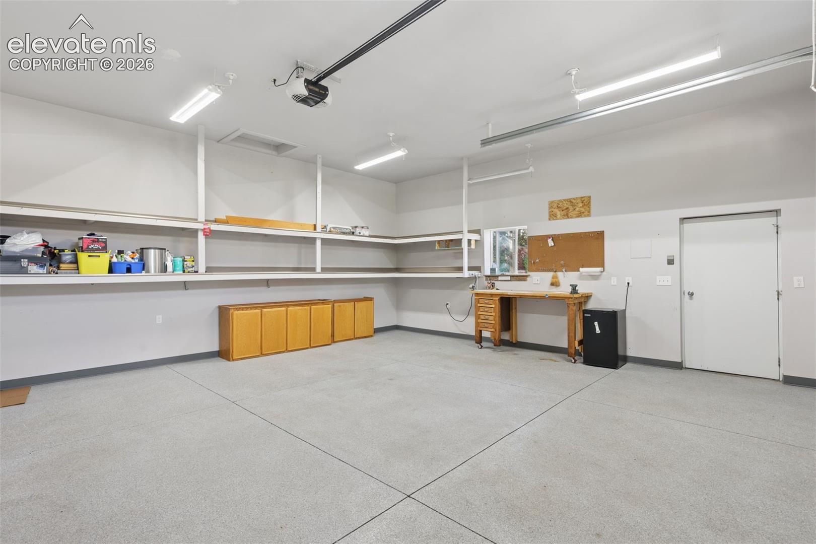 Over-sized detached garage-interior with BI shelves, drywall finish, epoxy floor finish, and extra storage in attic!