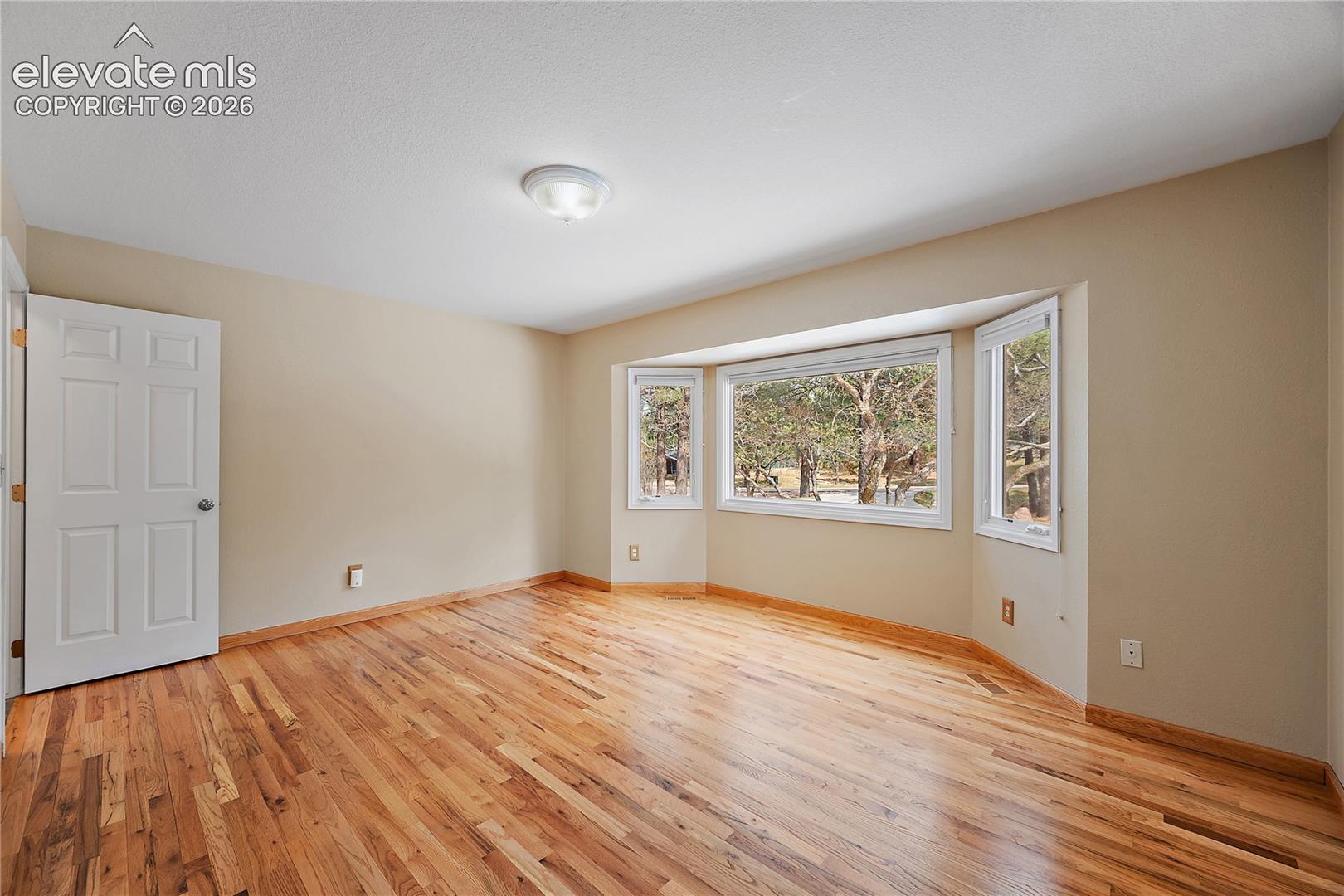 Main level guest bedroom with hardwood flooring. 