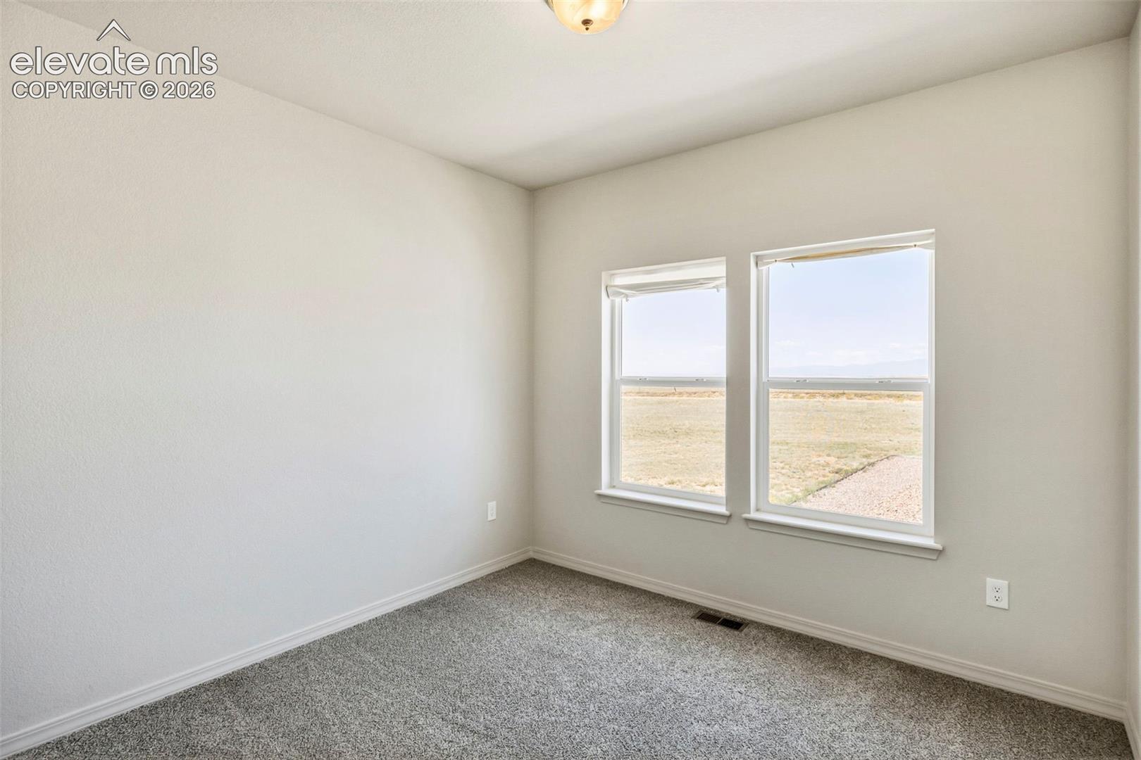 Neutral-toned room with light gray walls and plush gray carpeting