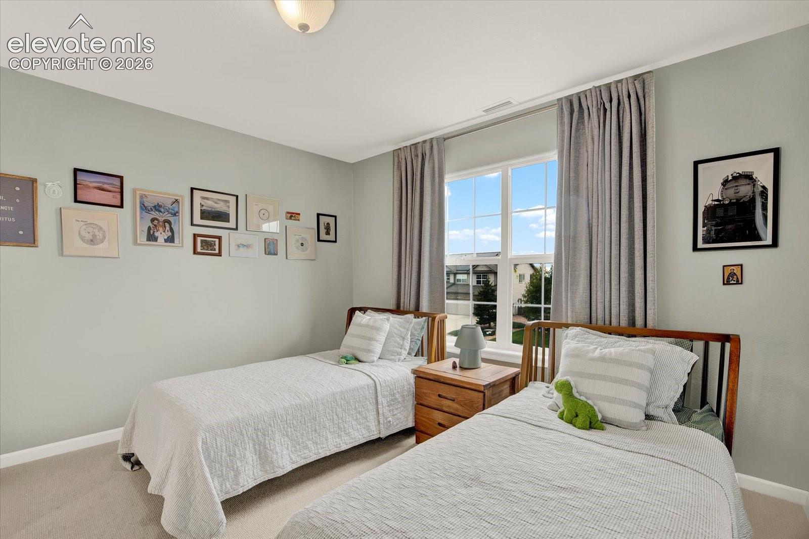 Neutral-toned wall paint, neutral carpeting, and a multi-pane window featuring natural light
