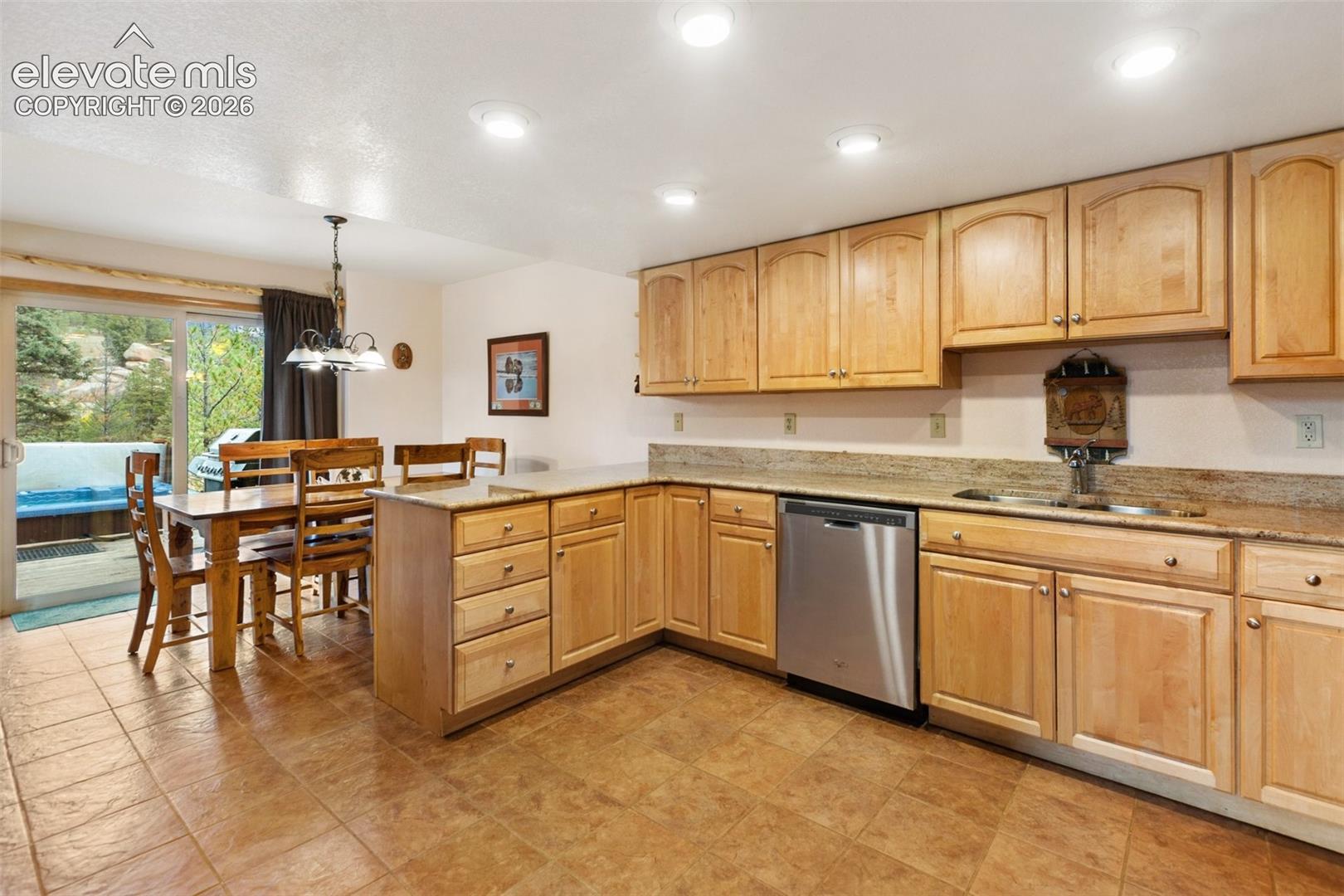 Kitchen featuring light wood cabinetry, granite countertops, and a stainless steel dishwasher