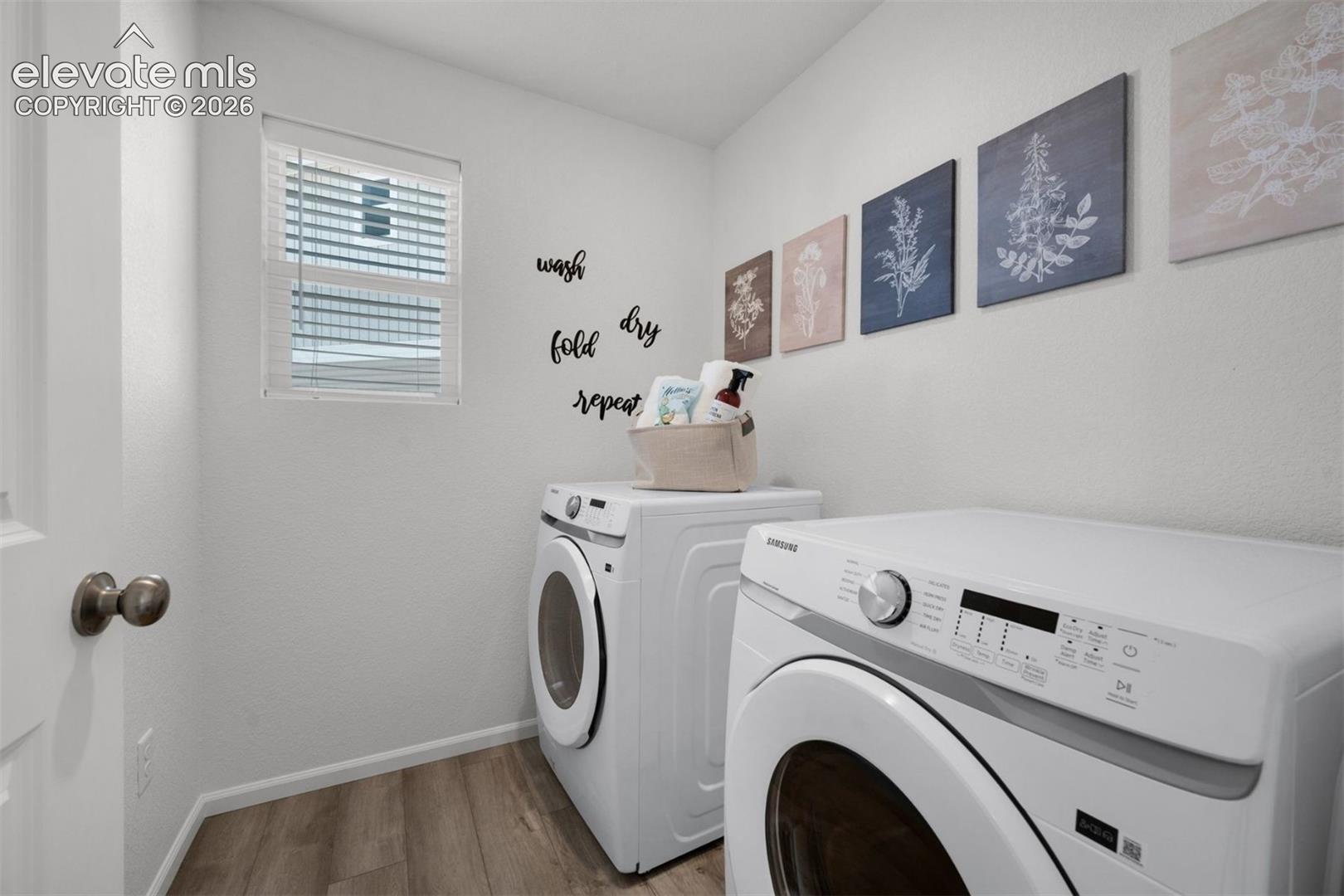 Room featuring a window with blinds, wood-finish flooring, and a white door with a bronze knob
*photos of a model home*