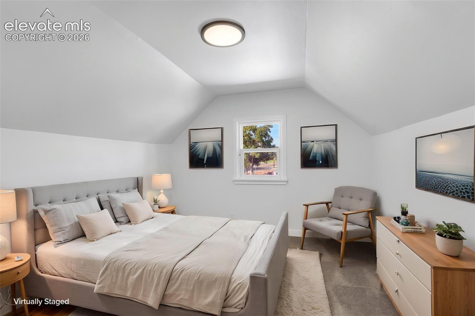Bedroom featuring sloped ceilings, carpeted flooring, and a central overhead flush-mount light fixture