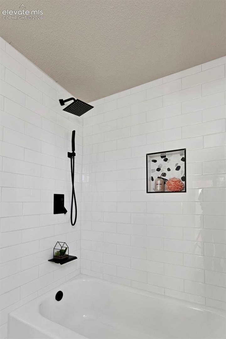 Bathtub and shower combination featuring white subway tile surround
