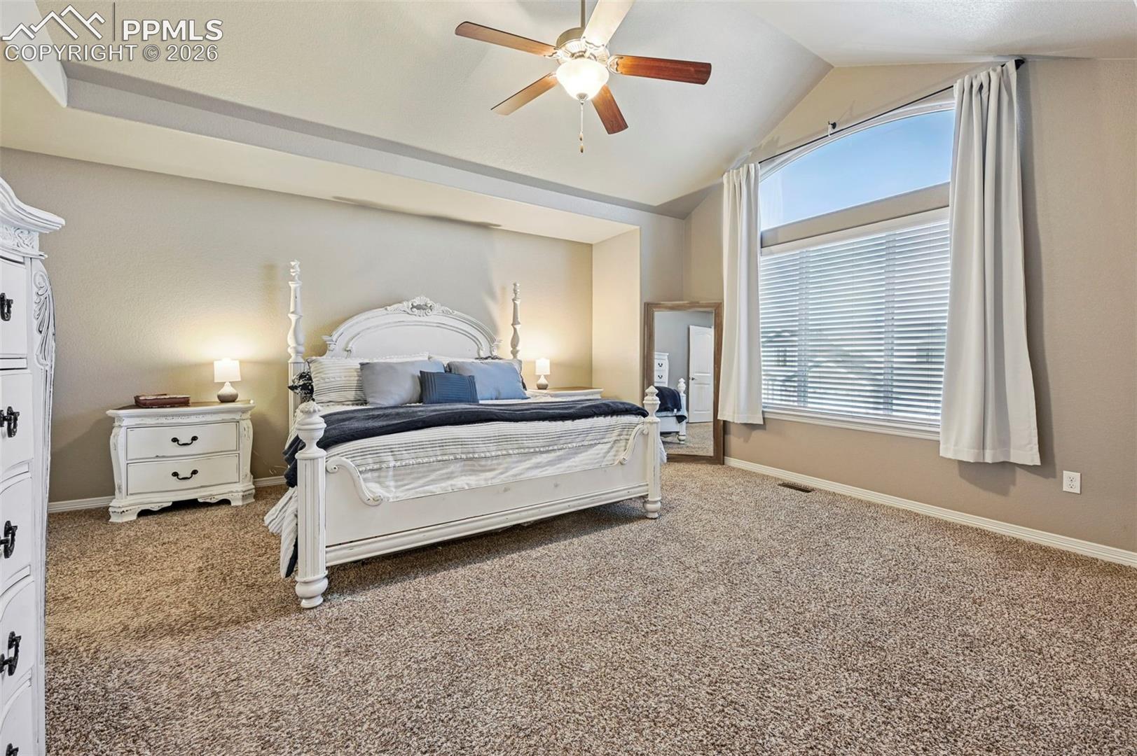 Carpeted bedroom with baseboards and a ceiling fan