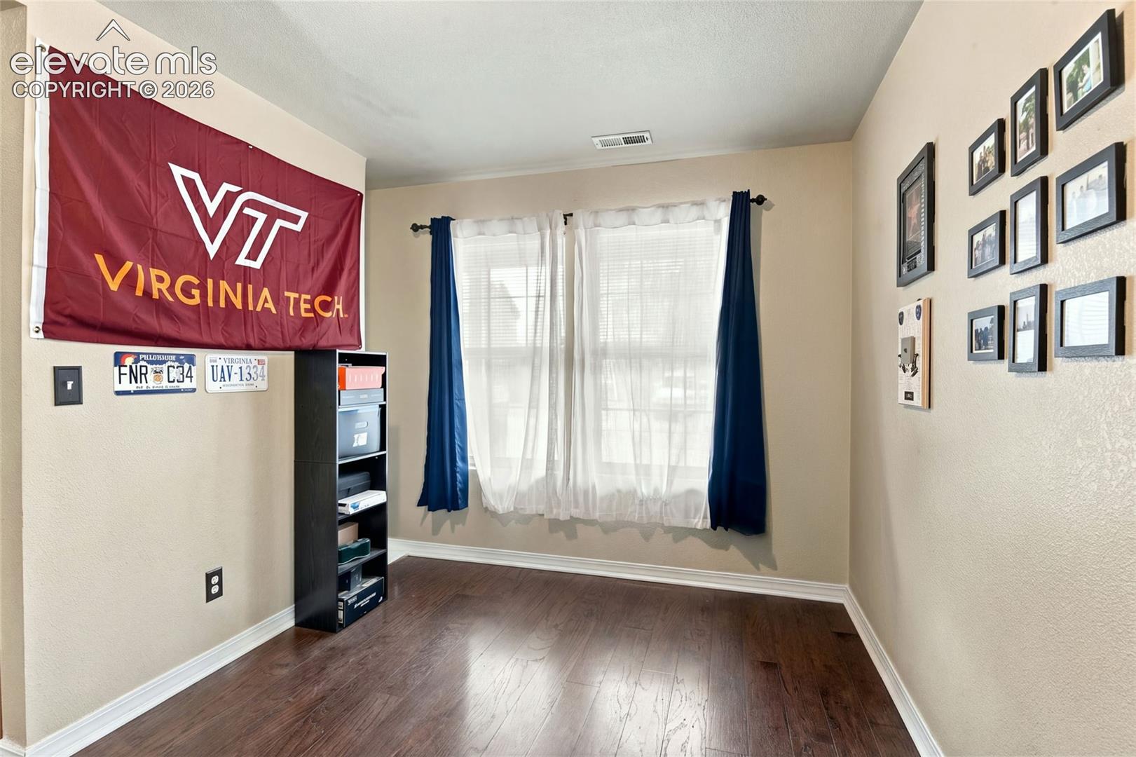 Room featuring wood-finish flooring, neutral wall paint, and double-pane windows