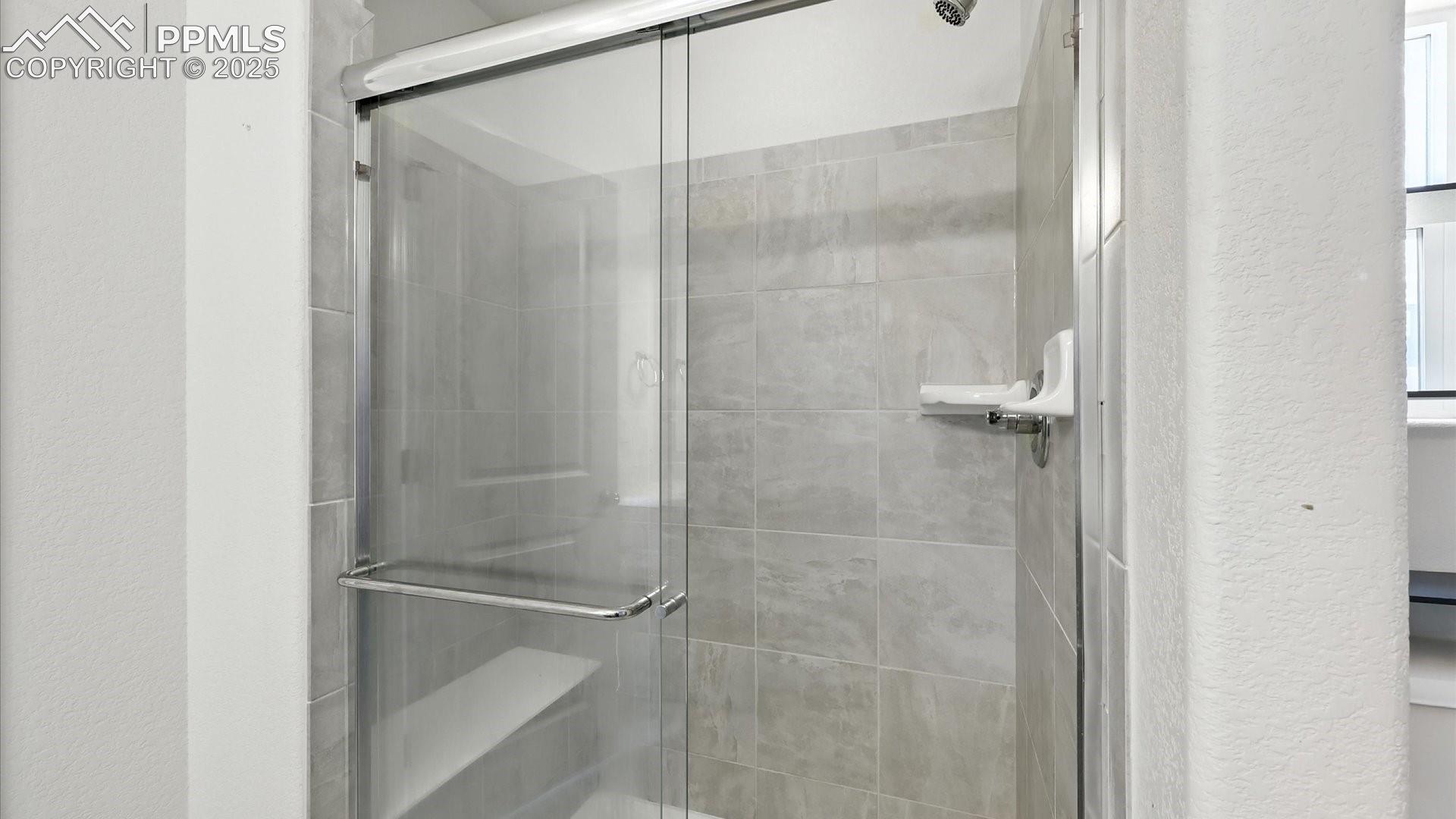 Enclosed tiled shower in the Primary Bathroom.