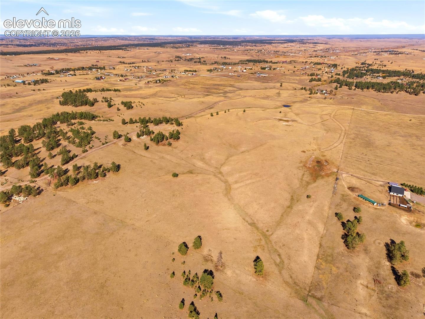 Expansive acreage featuring rolling topography, stands of evergreen trees, and native prairie grass