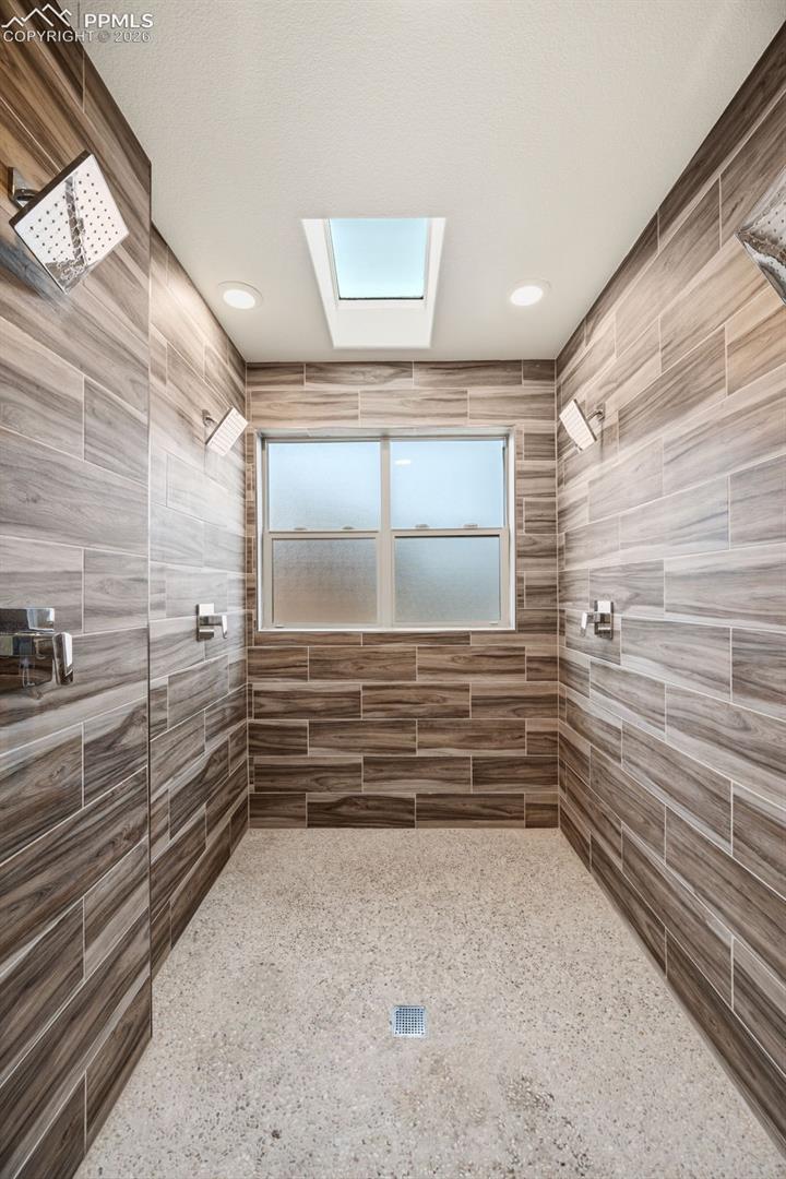 Spa shower room has 4 shower heads and skylight for plenty of natural light