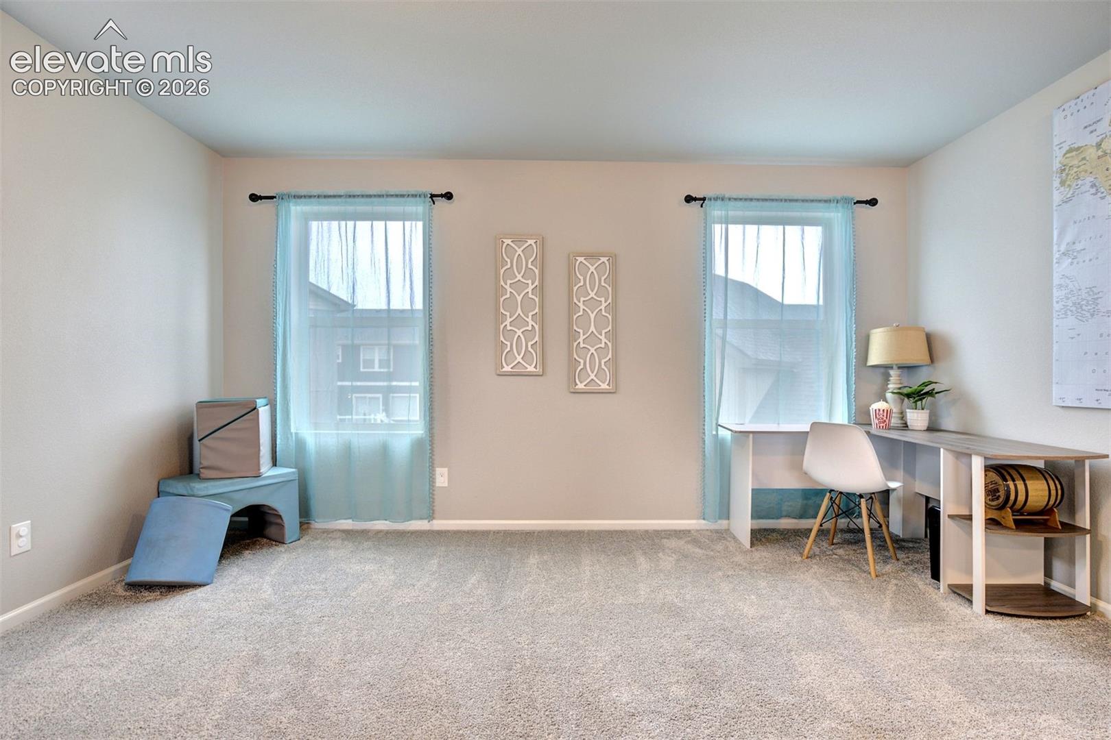 Neutral interior room featuring plush carpeting, dual windows, and recessed lighting