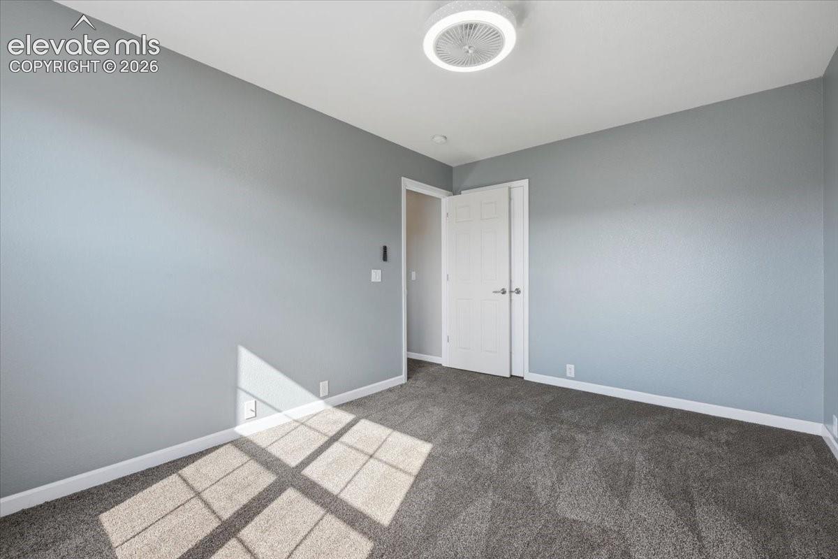 Bedroom 2 - Neutral-toned walls, textured carpet flooring, and a contemporary flush-mount ceiling light