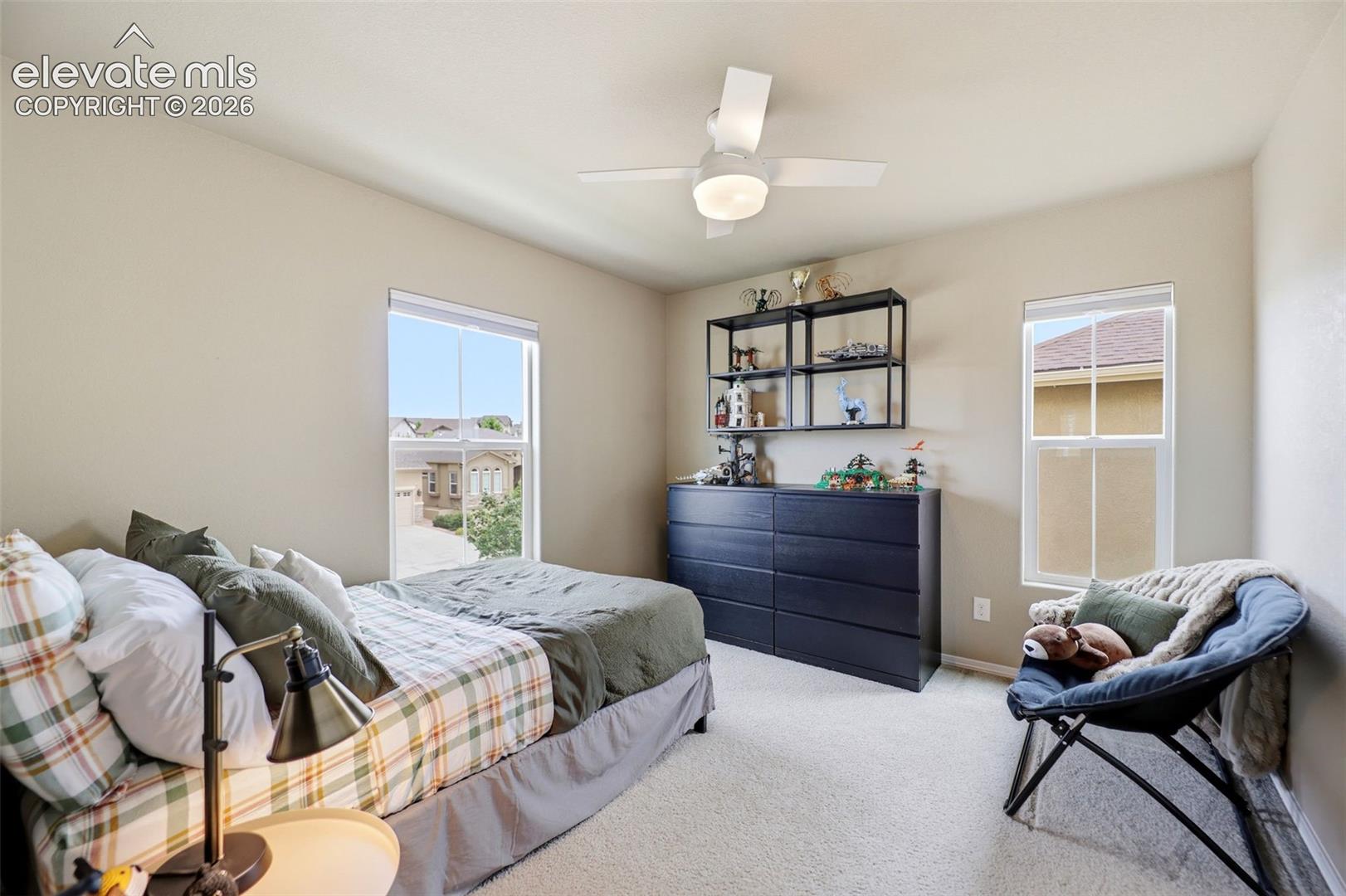 Recessed ceiling lighting, a modern ceiling fan, and light-toned carpeting