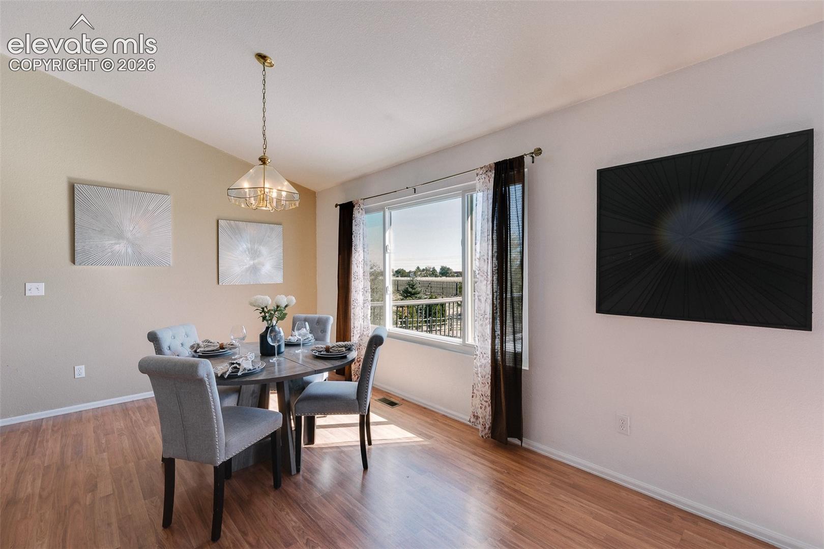The Dining Area has LVP flooring, an attractive light fixture, & looks out over the backyard.