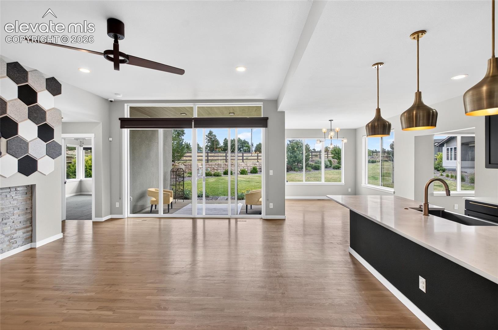 view of center island kitchen on right and fireplace on left- outdoor patio straight aheaad