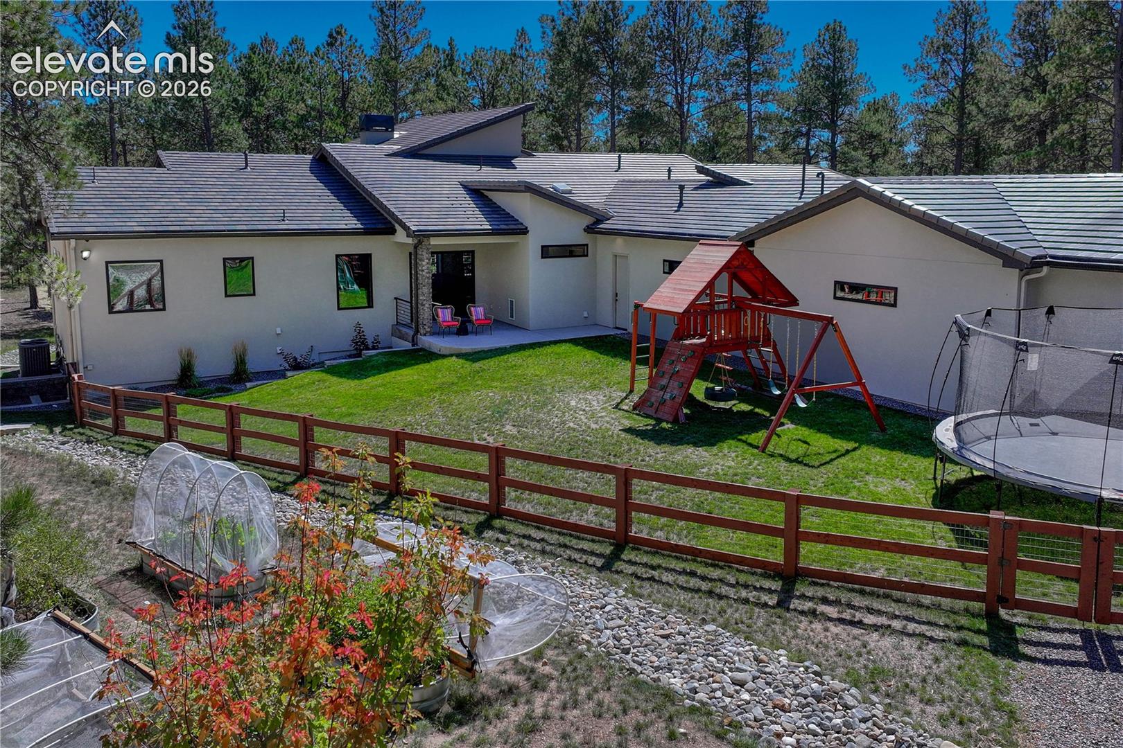 Back of property featuring stucco siding, a patio area, a lawn, and a balcony