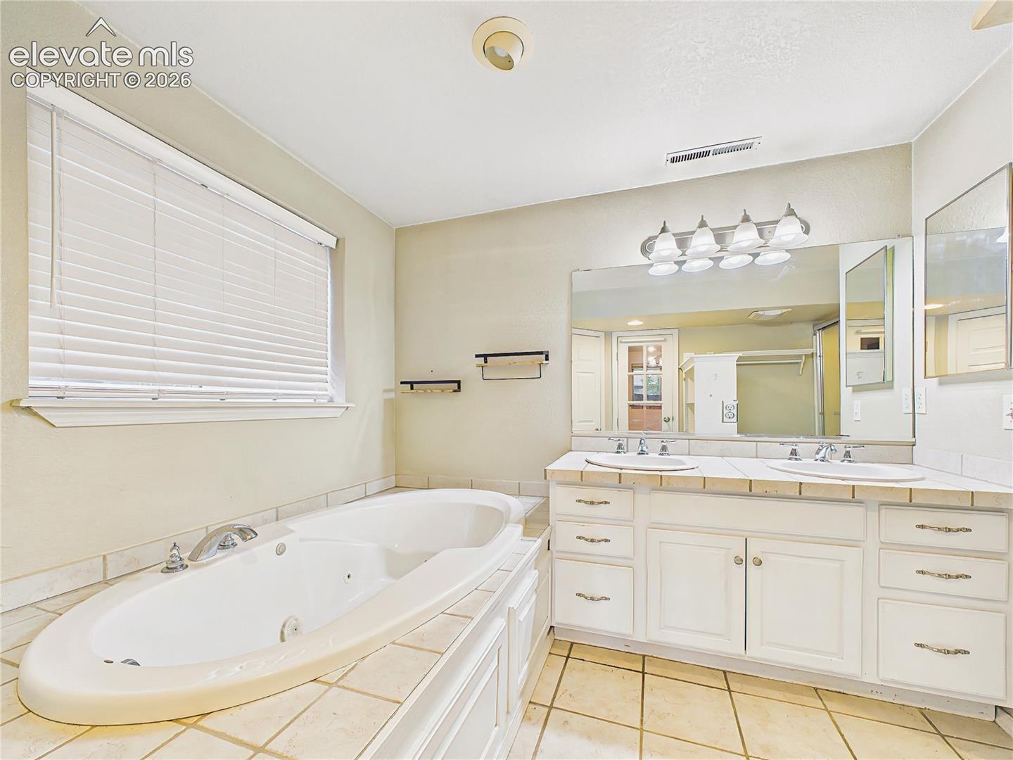 Spacious primary bath with dual vanities, a soaking tub, and ample counter space designed for everyday comfort. Lower Level