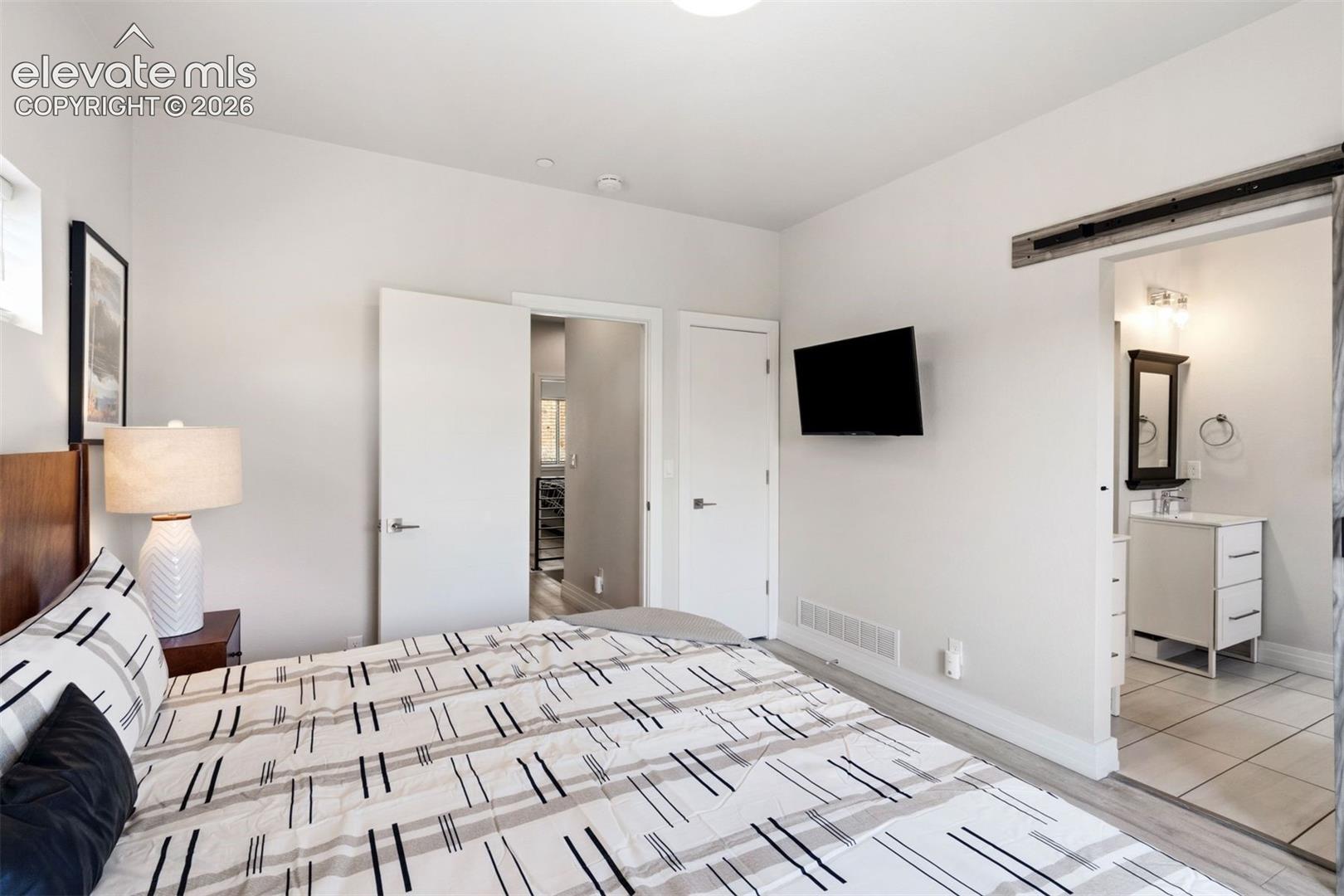 Primary bedroom with ensuite bathroom, walk-in closet, and private deck with roof top access