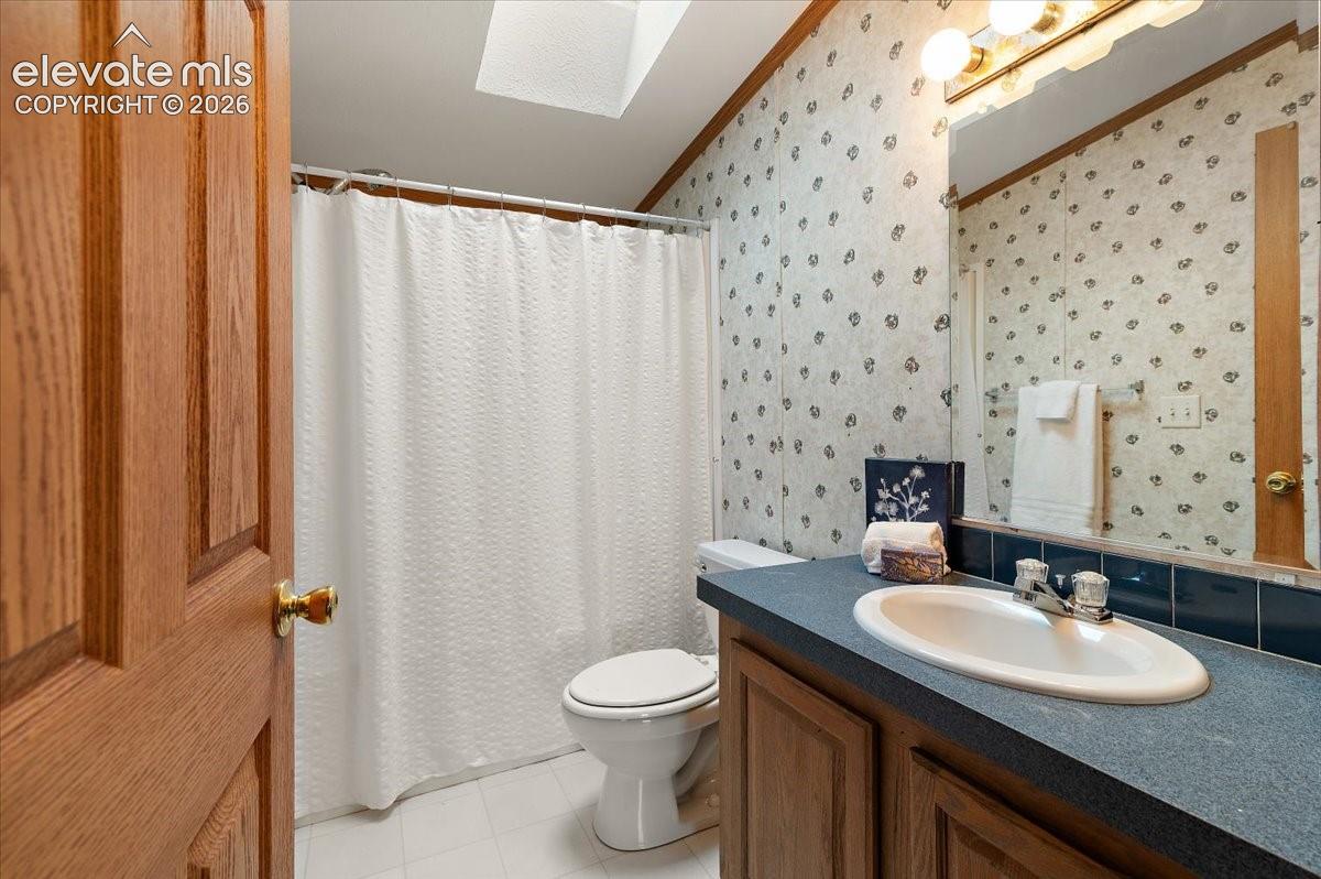 Bathroom featuring a vanity with an integrated sink, built-in cabinetry, wall-mounted mirror, and overhead light fixture