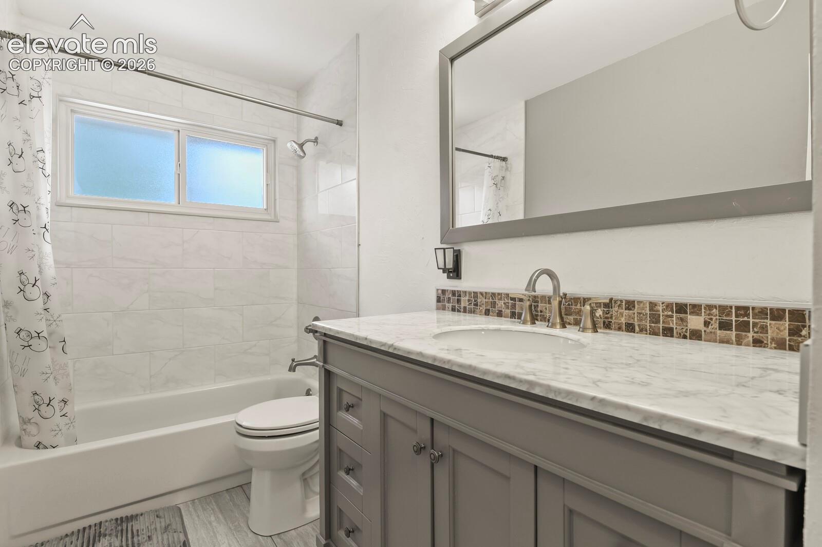 Bathroom featuring a white bathtub with subway tile surround, and a frosted window