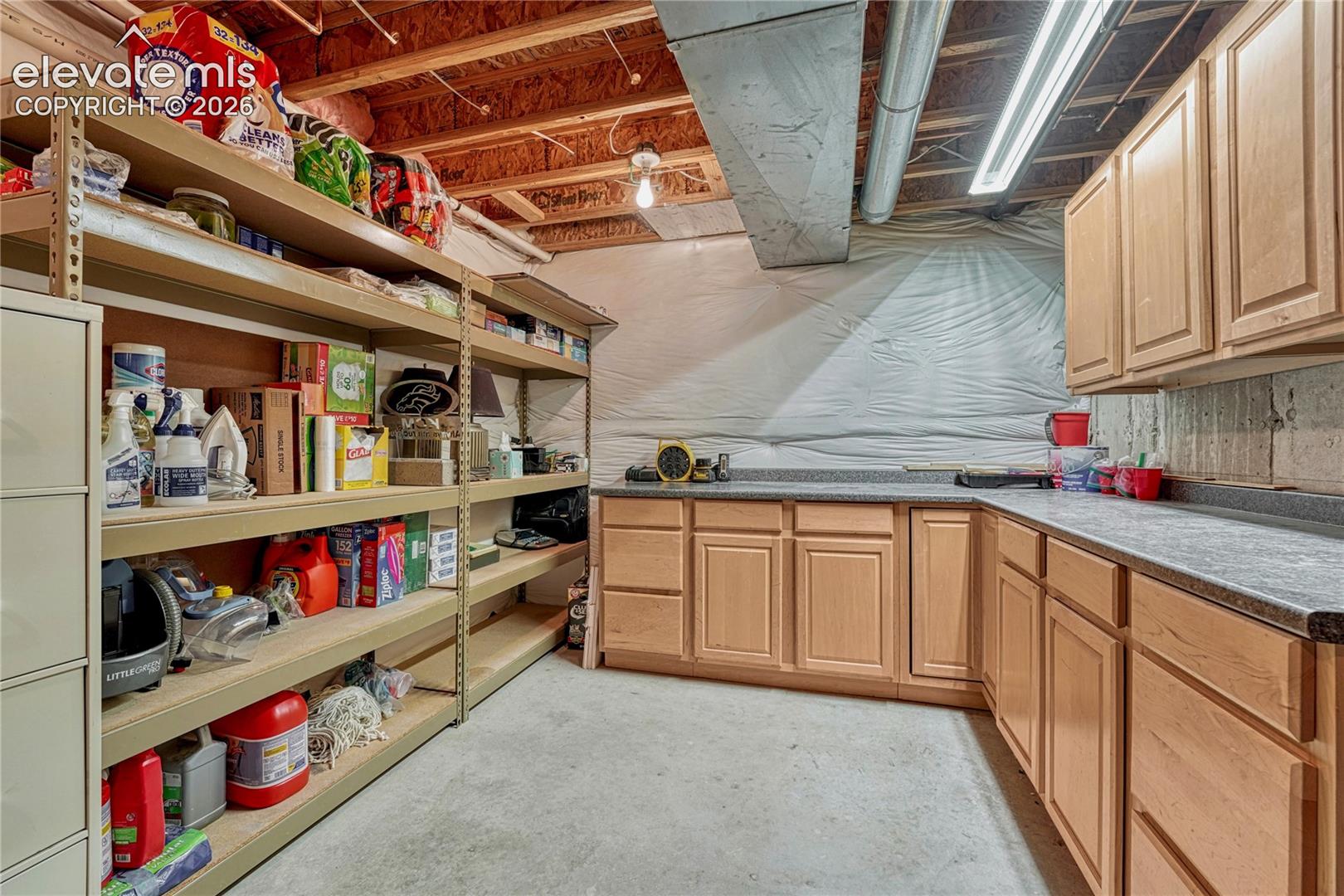 The dedicated workshop room includes generous counter workspace and abundant upper/lower cabinets that stay with the home (south-facing shelving is excluded)

