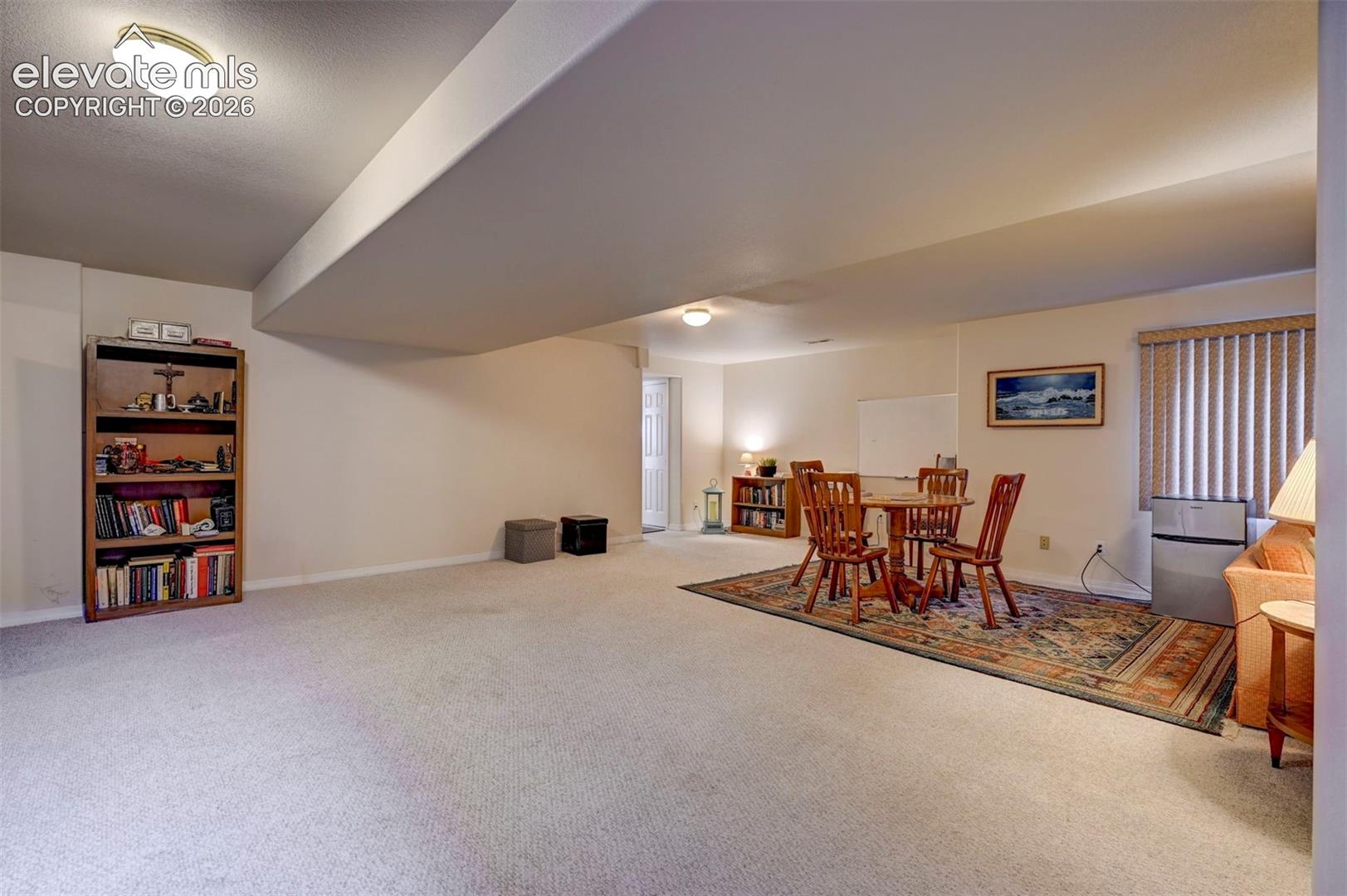 Huge basement room area with card/game table area. Carpet.