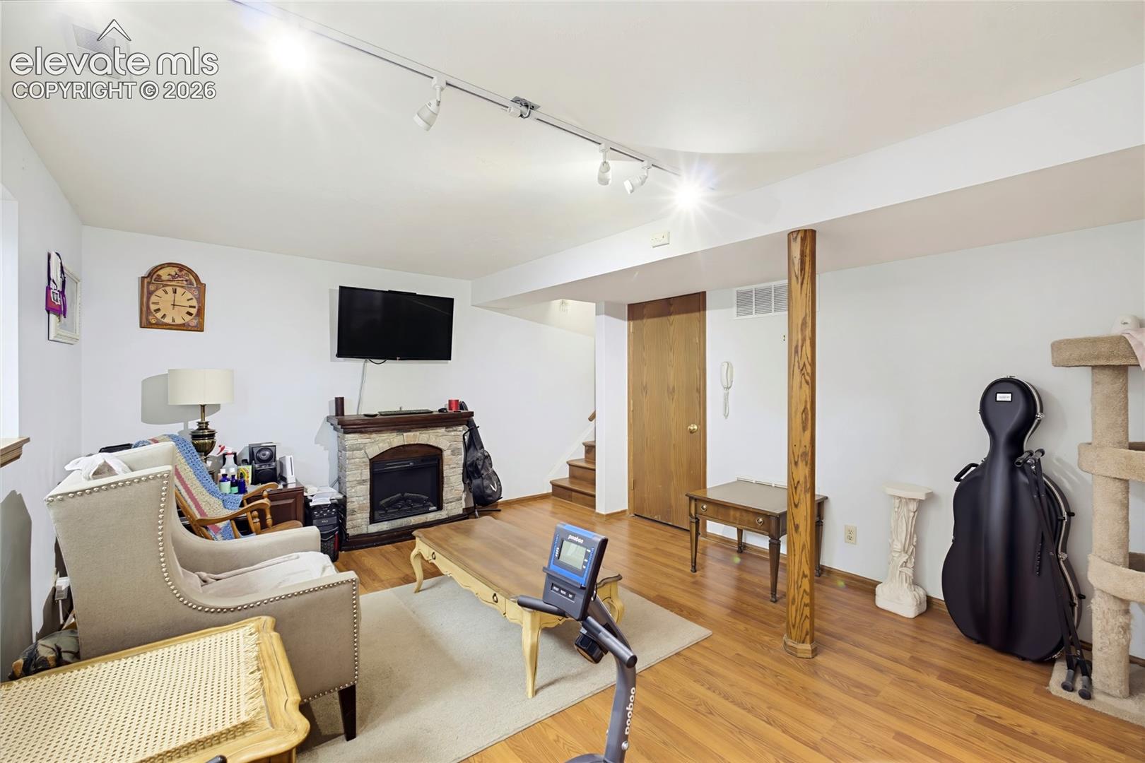 Wood-finish flooring throughout, complemented by recessed lighting and a stone-clad fireplace